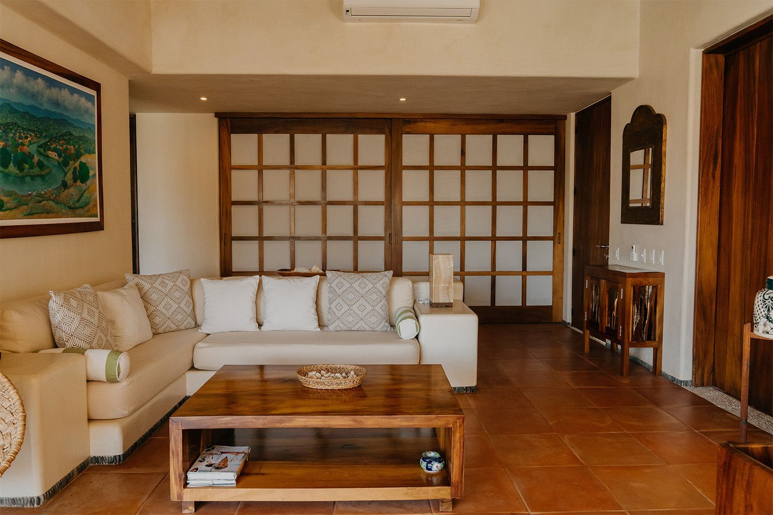 Una sala de estar con sofá, mesa de café y puertas corredizas de vidrio.