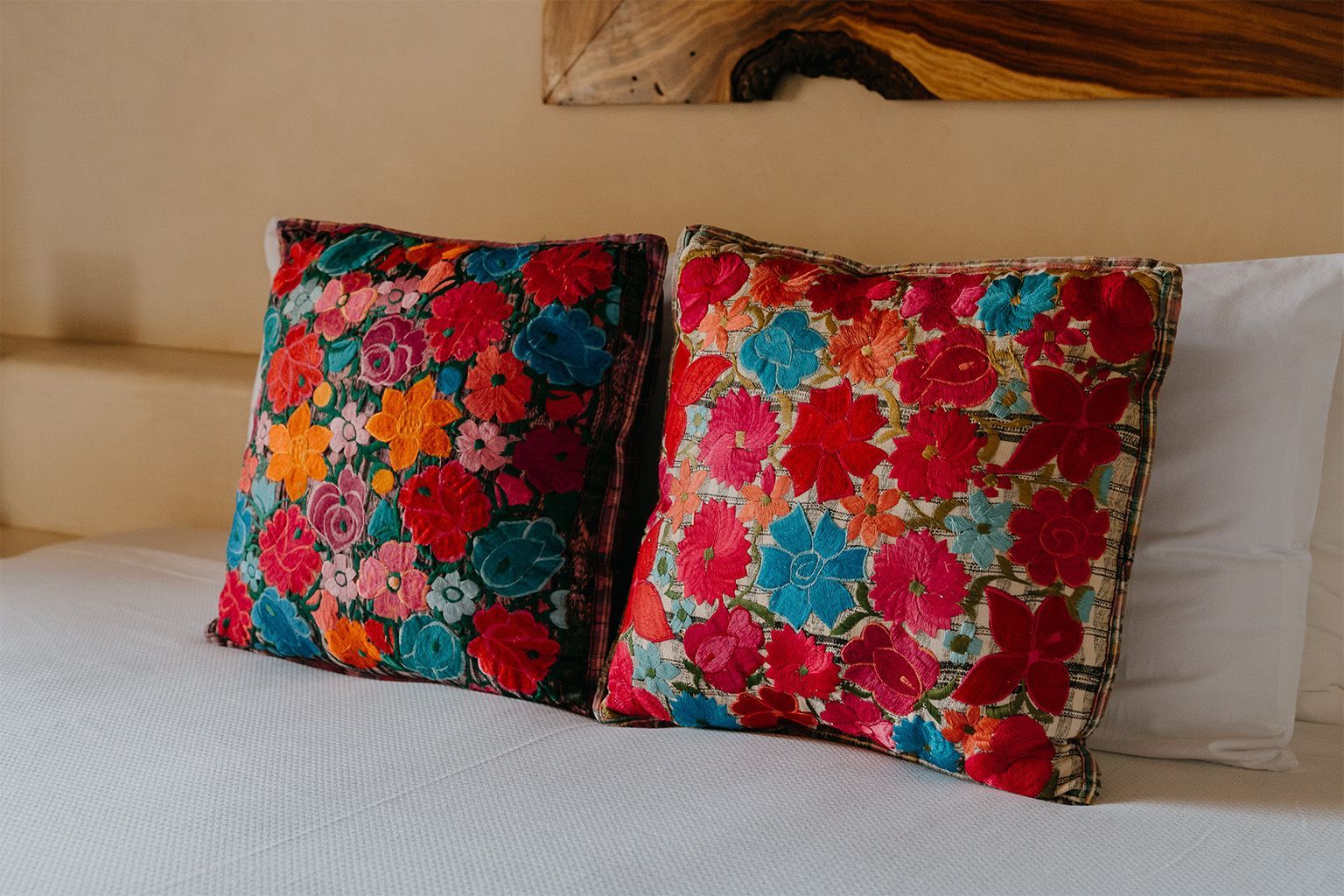 Dos almohadas de colores están sentadas sobre una cama.