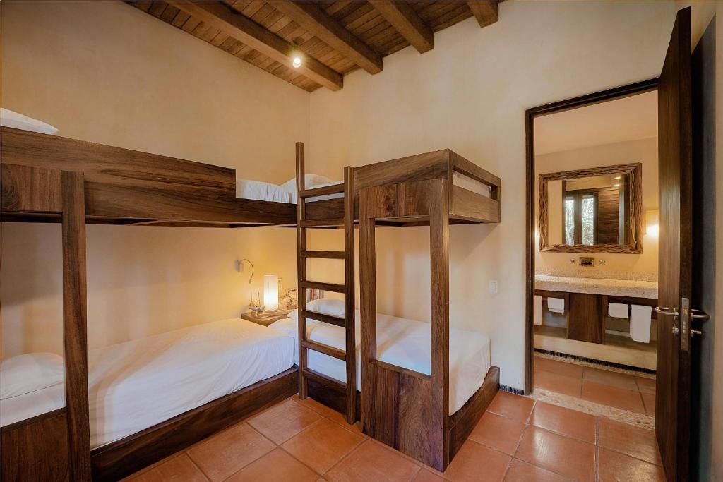 Un dormitorio con tres literas y un baño.