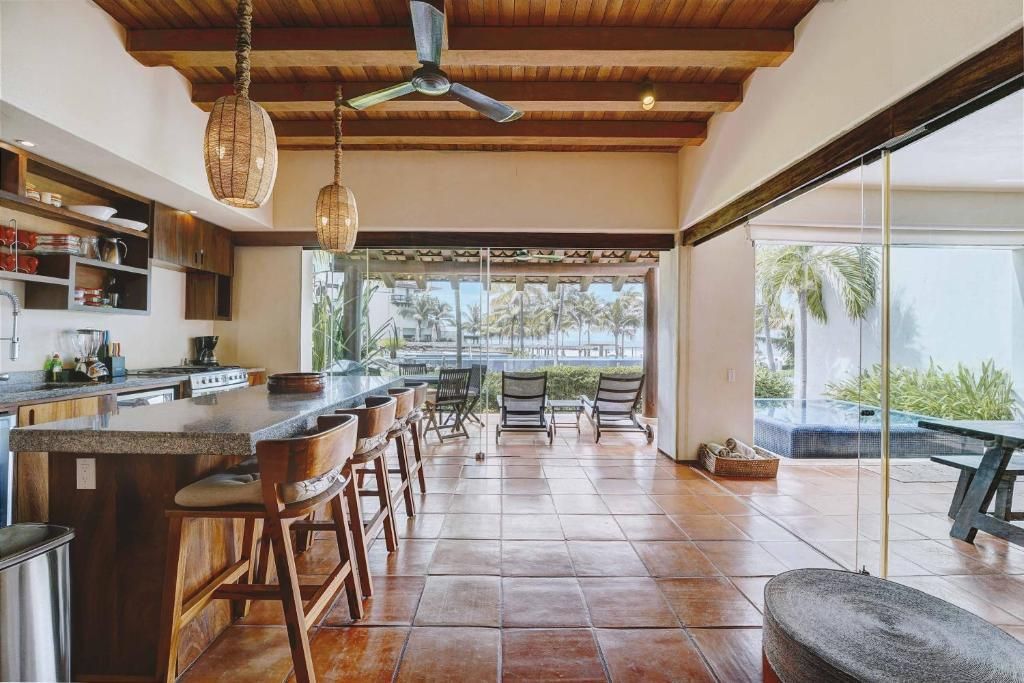 Una habitación grande con muchas ventanas y un ventilador de techo.