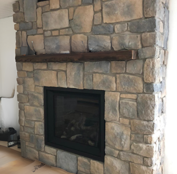 Cheminée en pierre avec manteau en bois foncé et insert de cheminée noir.