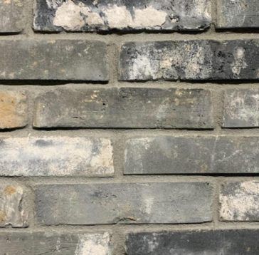 Mur de briques grises avec couleurs et textures variées.