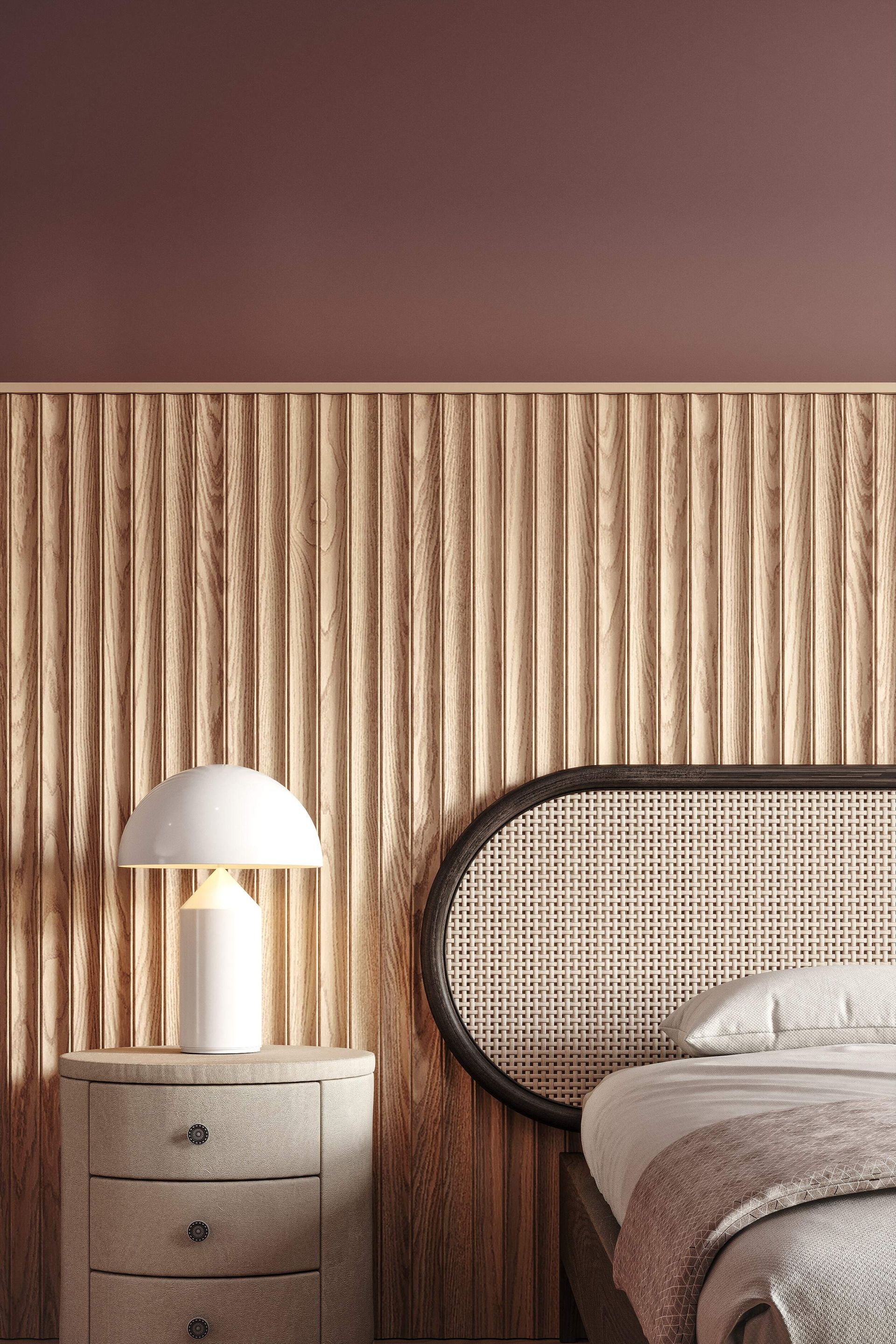 Chambre avec tête de lit à panneaux en bois et table de chevet avec lampe. Le mur est peint en rouge profond.