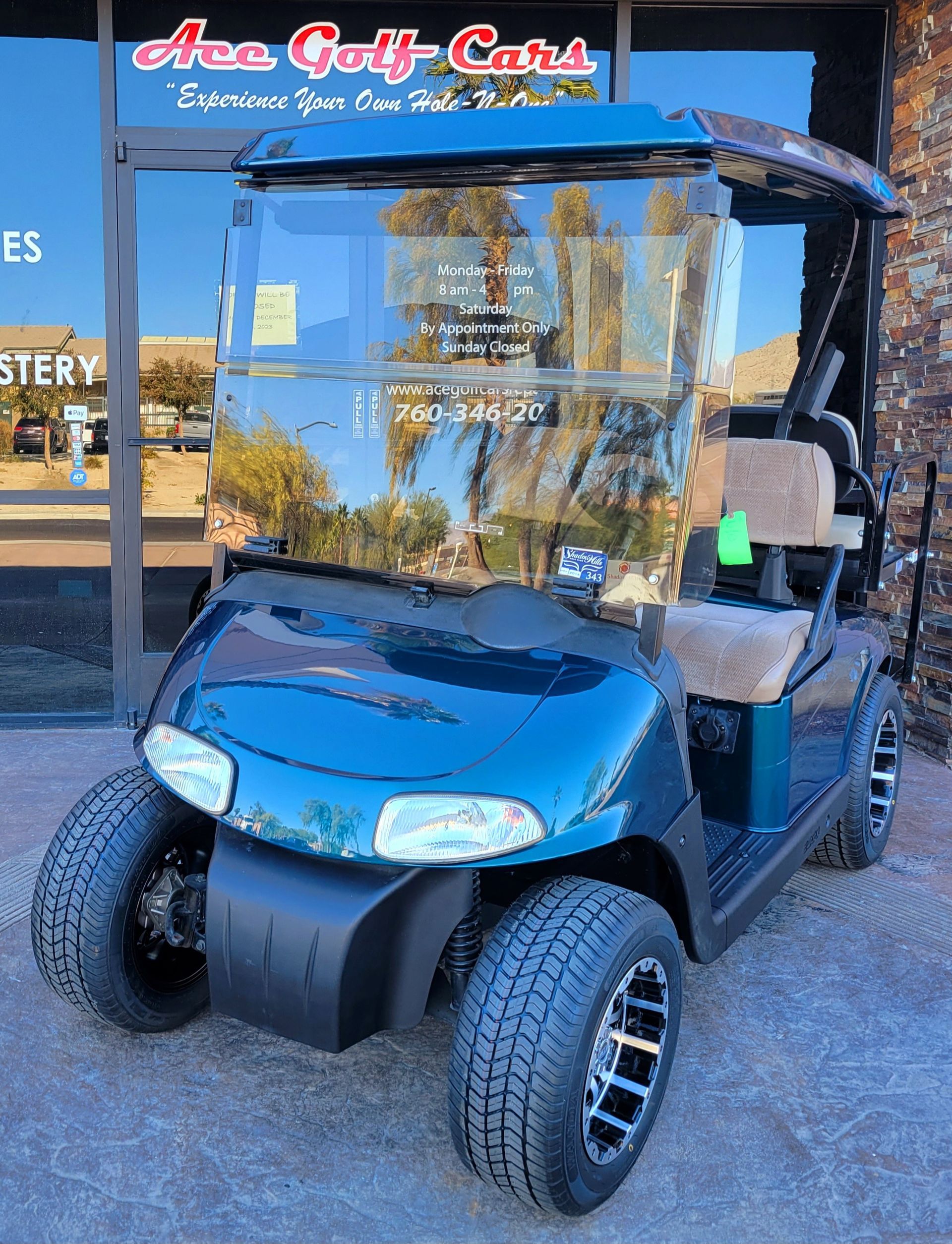 A blue golf cart is parked in front of a store.