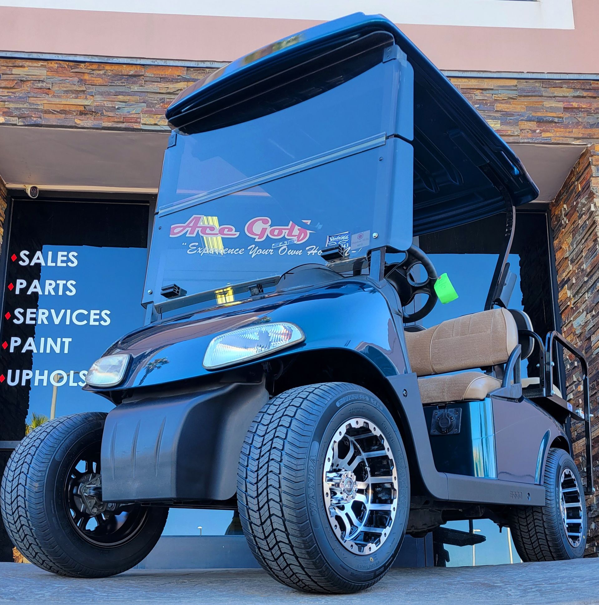 A black golf cart is parked in front of a store