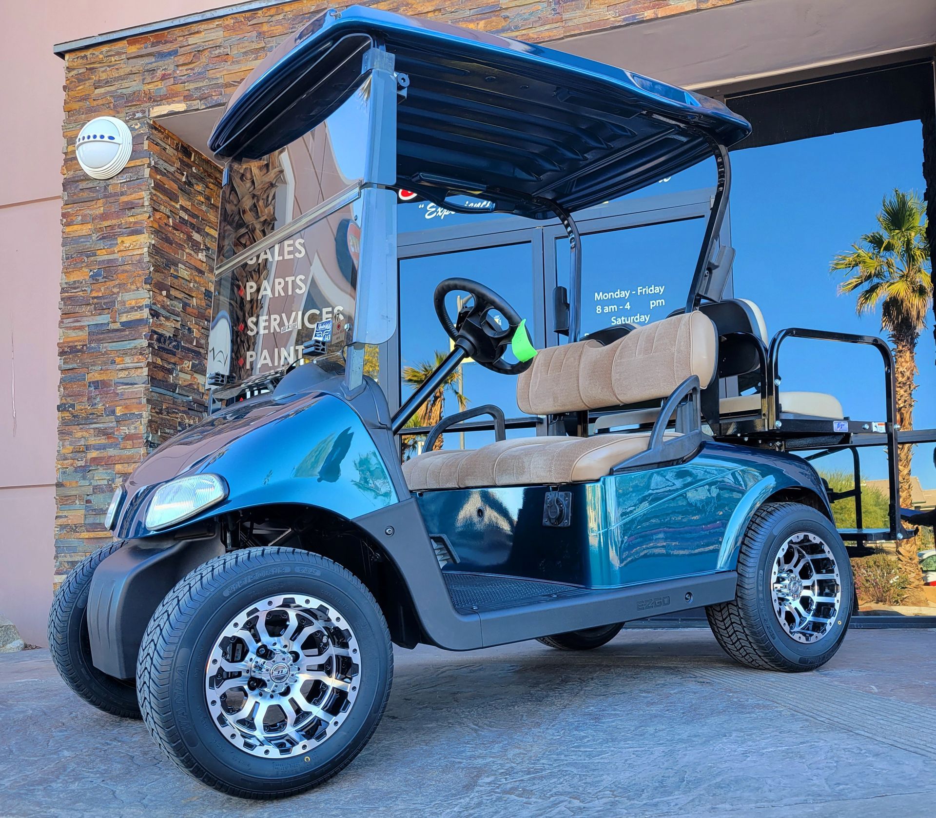A blue golf cart is parked in front of a building.