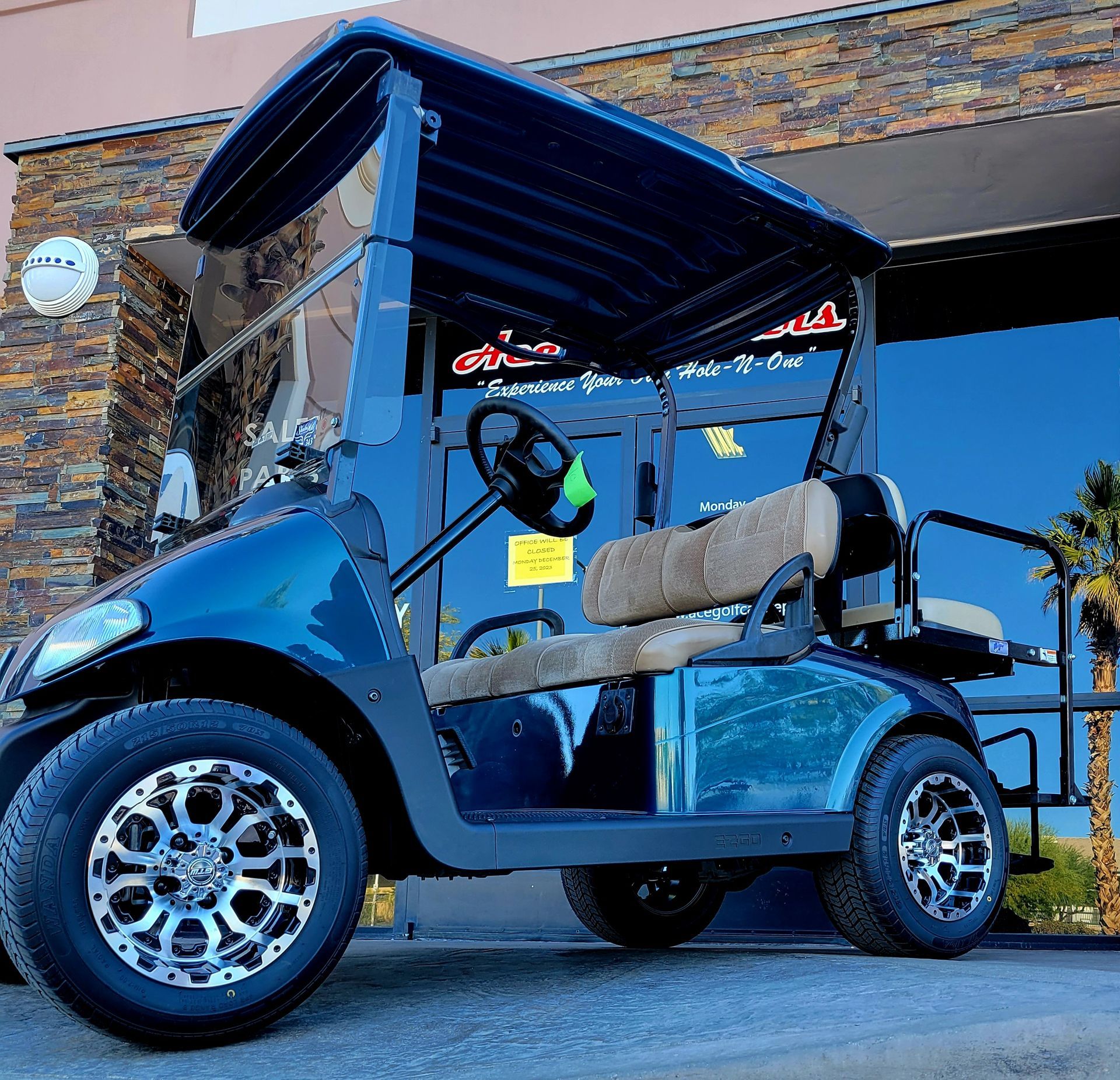 A black golf cart is parked in front of a building
