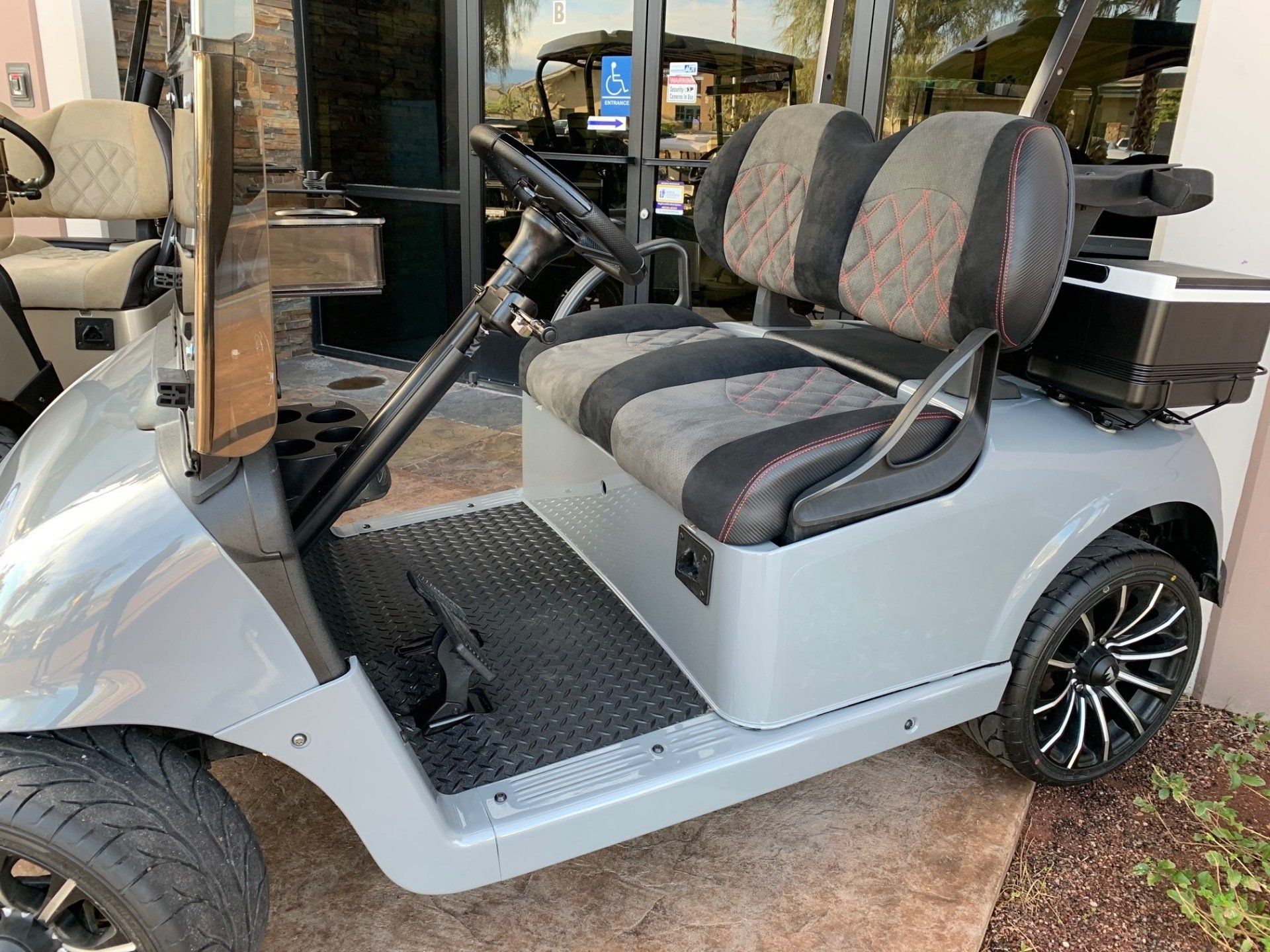 A golf cart is parked in front of a building.