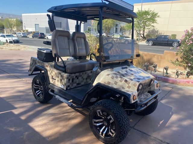 A golf cart is parked on the sidewalk in front of a building.