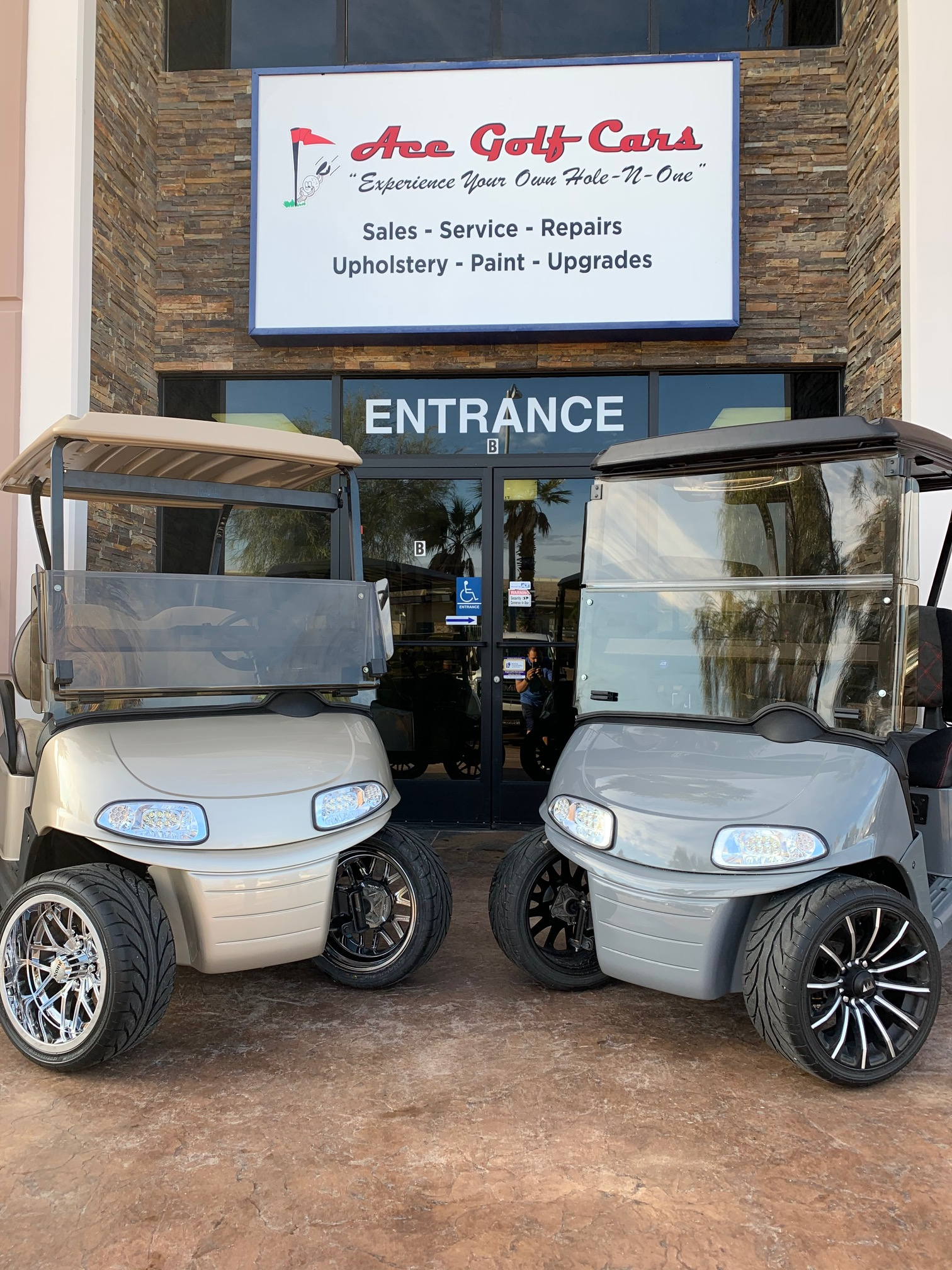 Two golf carts are parked in front of a building.