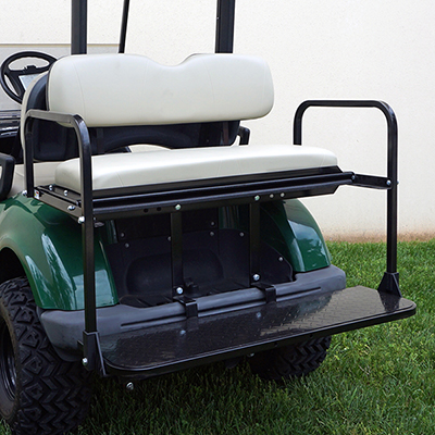 A green golf cart with a white seat is parked in the grass