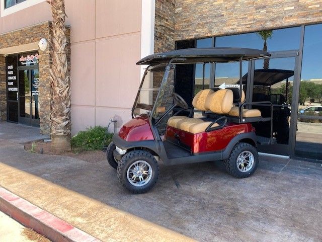 A red golf cart is parked in front of a building