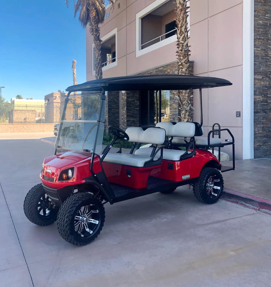 A red golf cart is parked in front of a building