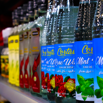 Several bottles of rose water sit on a shelf