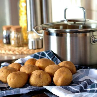 Potatoes on a towel next to a pot