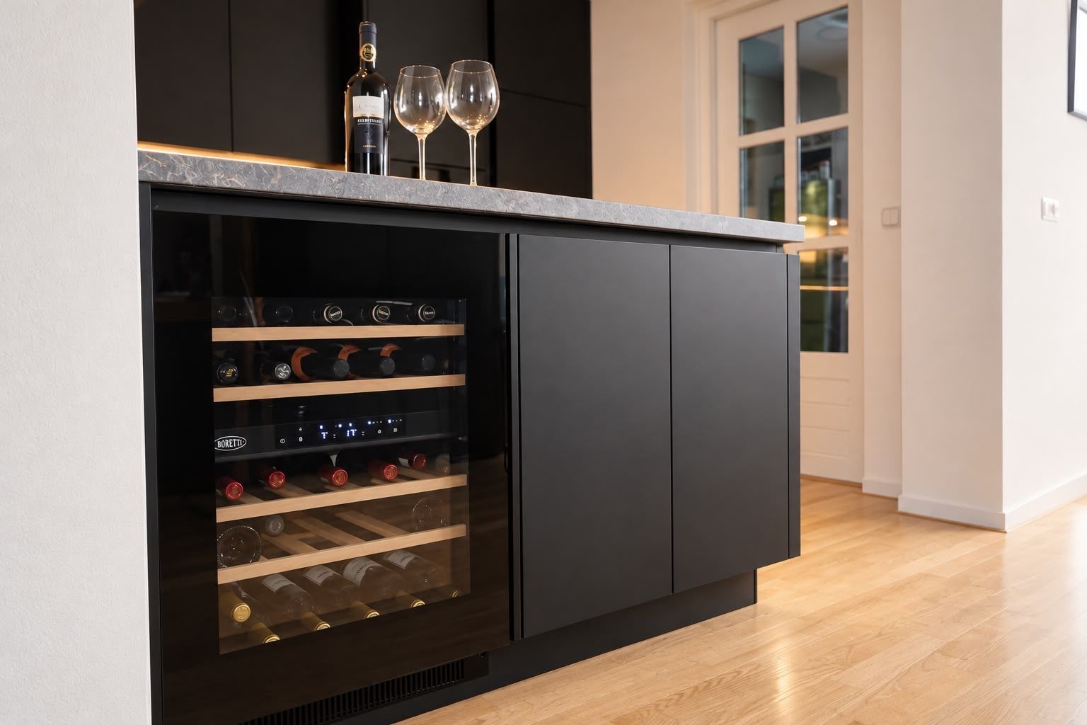 Moderne keuken met een wazig, warm verlicht woonkamer op de achtergrond.