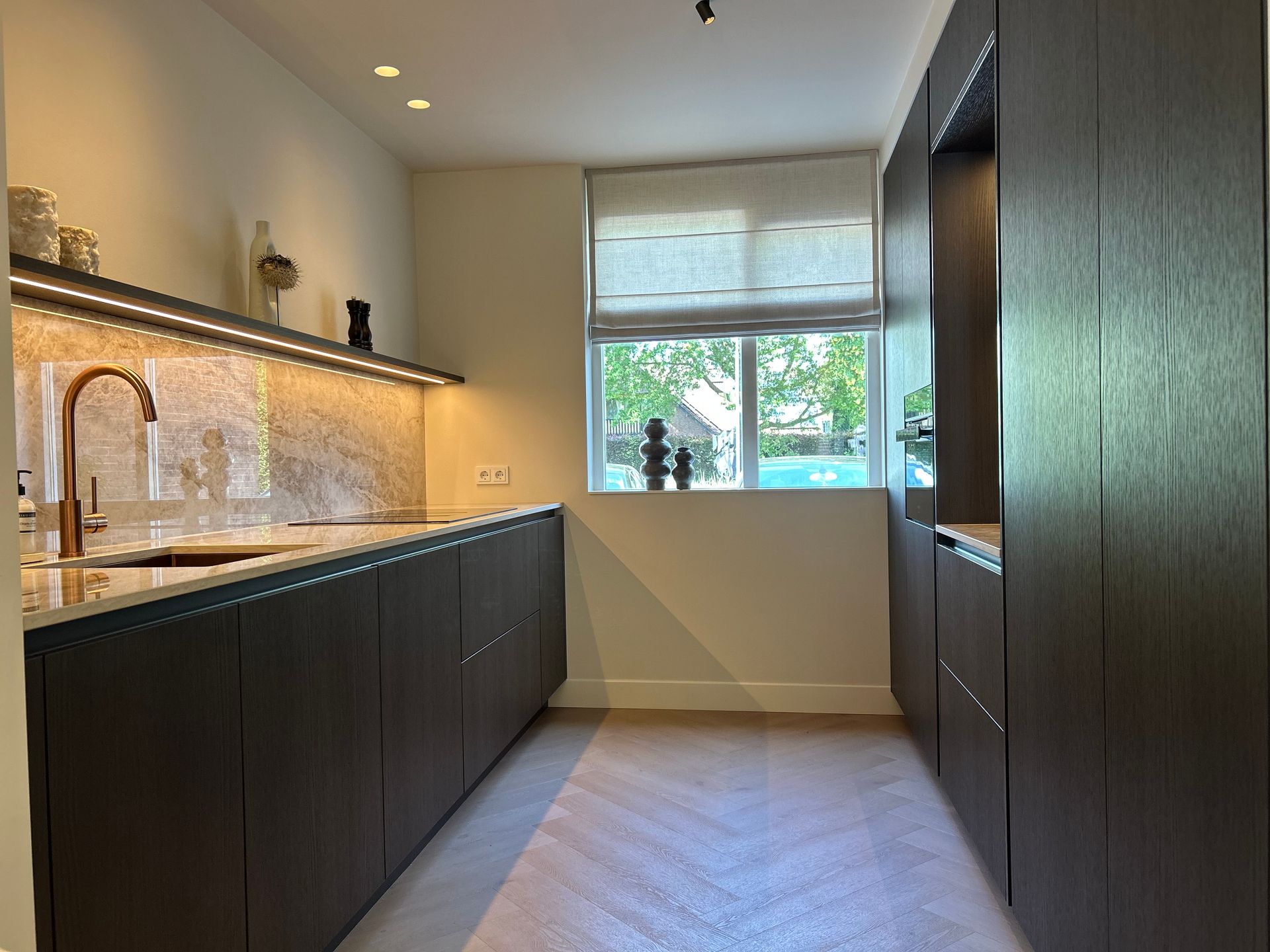 Moderne keuken met een wazig, warm verlicht woonkamer op de achtergrond.