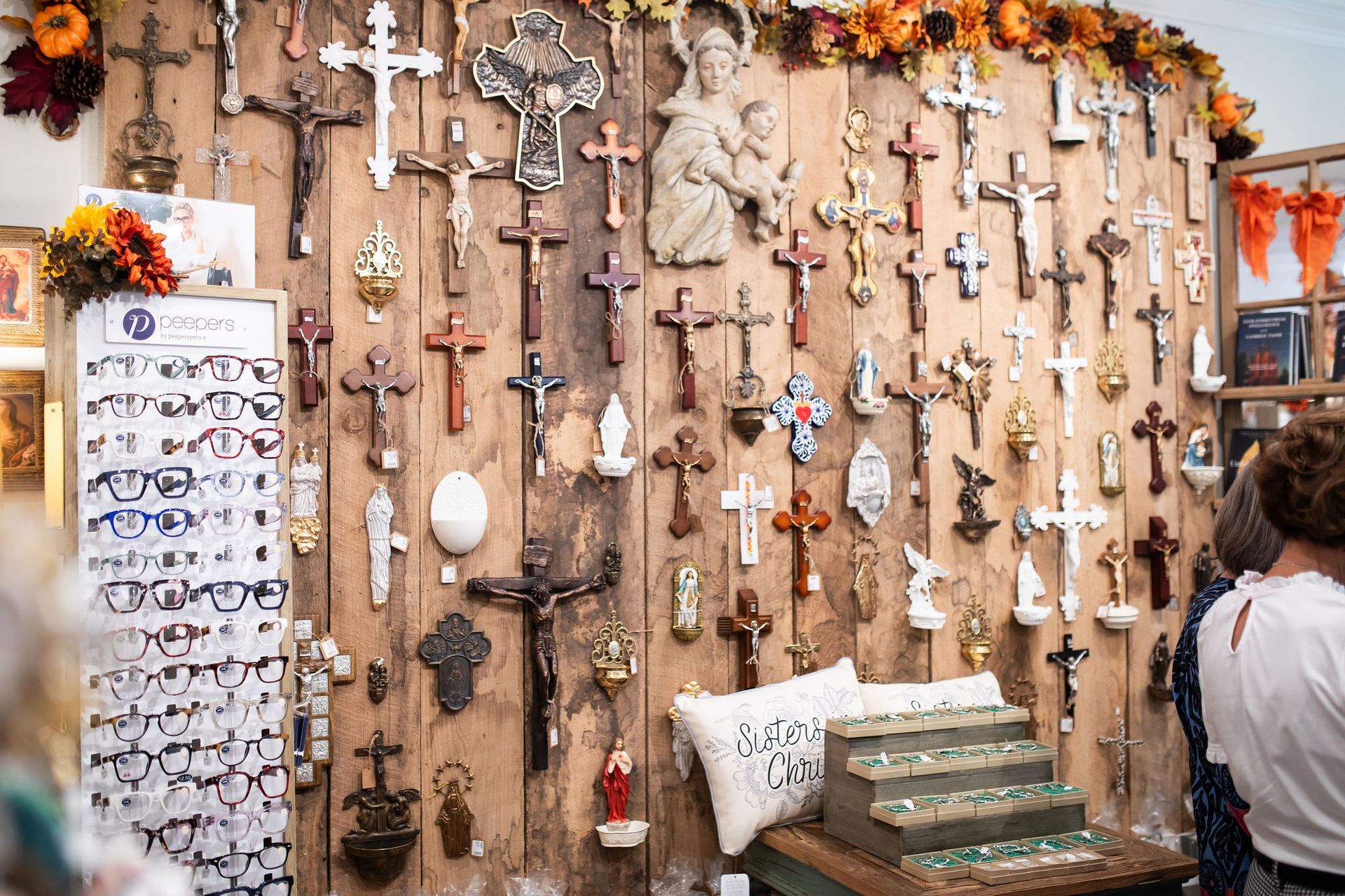 Wall display with many crosses and religious figurines for sale.