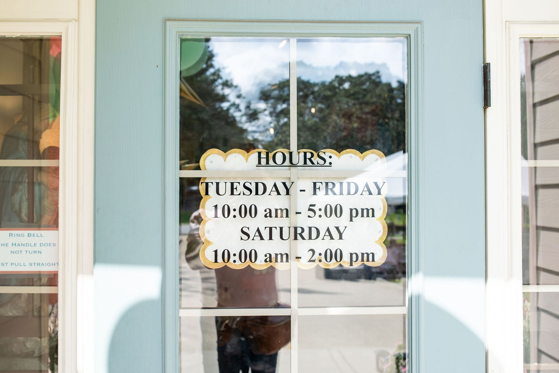Store door with hours: Tuesday-Friday 10 am-5 pm, Saturday 10 am-2 pm.