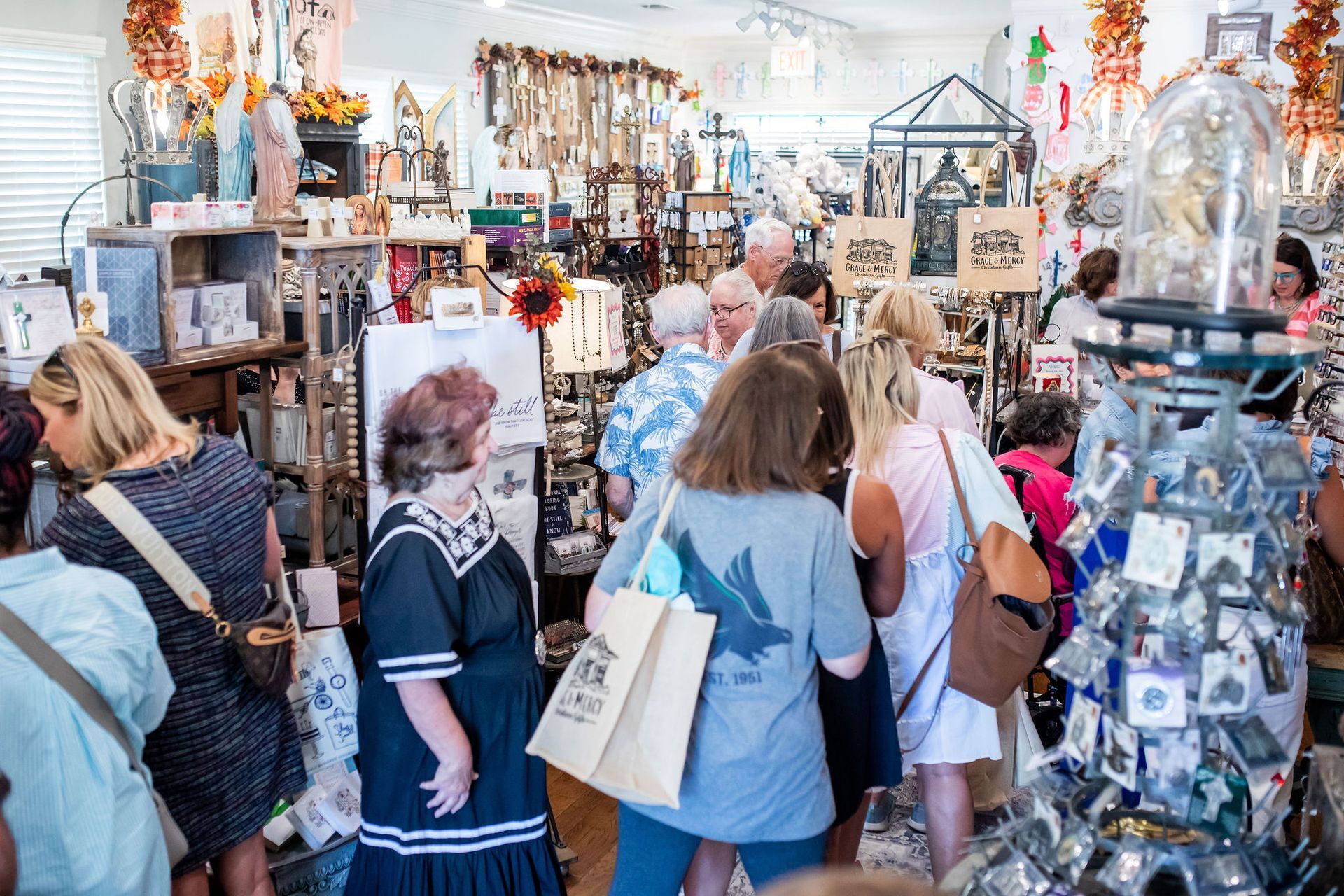People browsing inside a crowded gift shop, filled with merchandise.