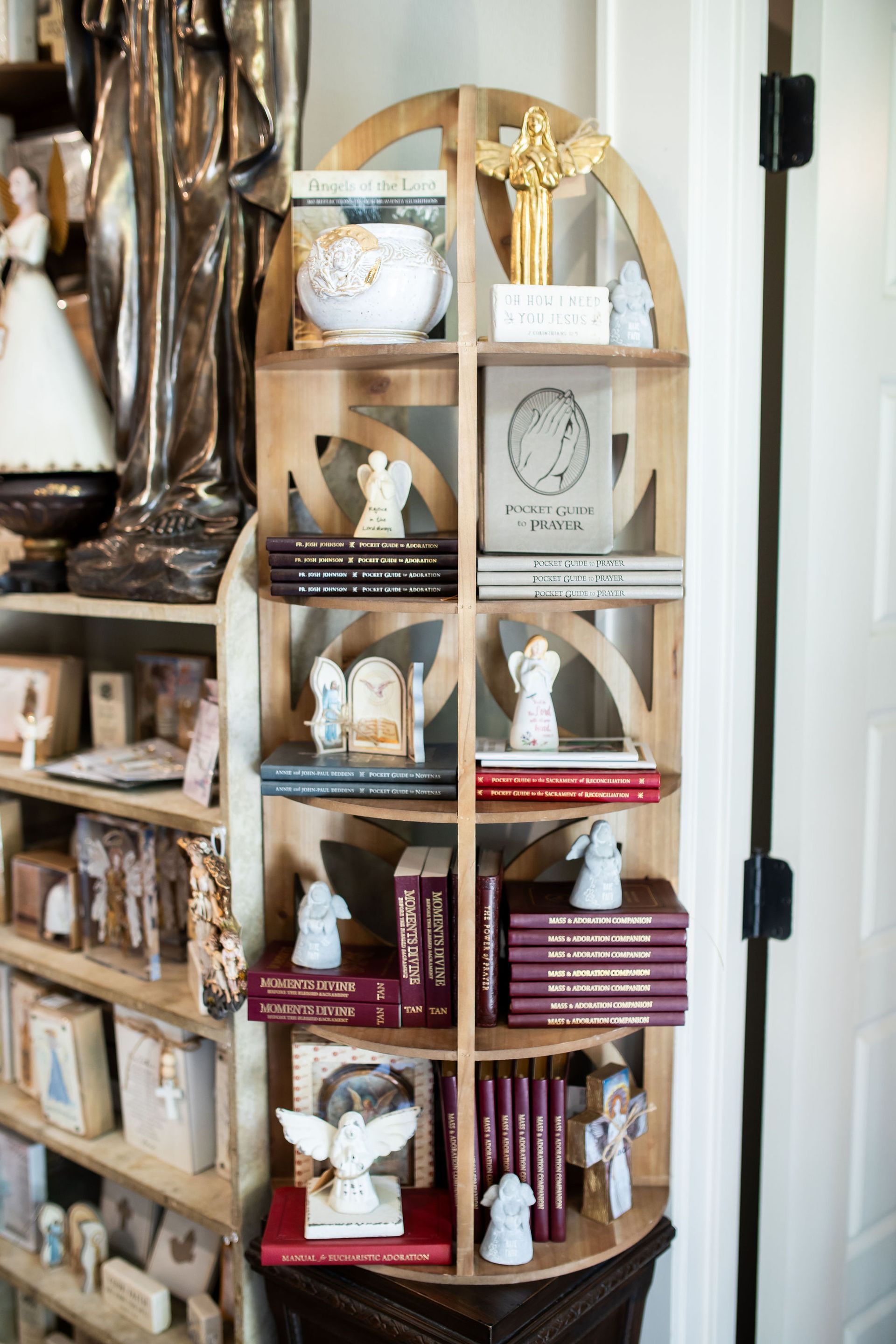 Wooden bookshelf filled with books, angel figurines, and decorative items.