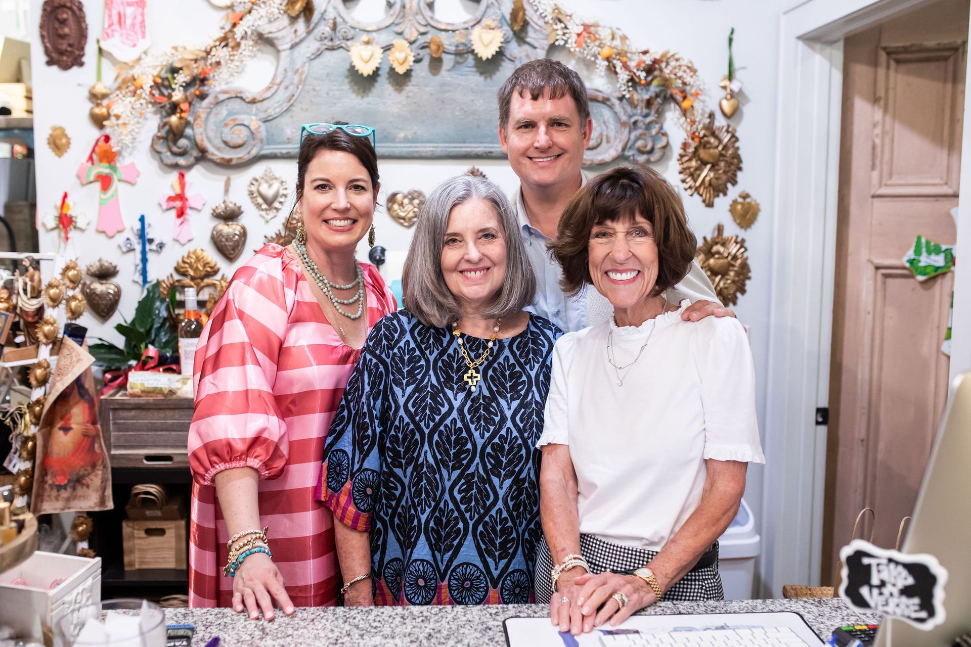 Four people smiling inside a shop with decorative items.