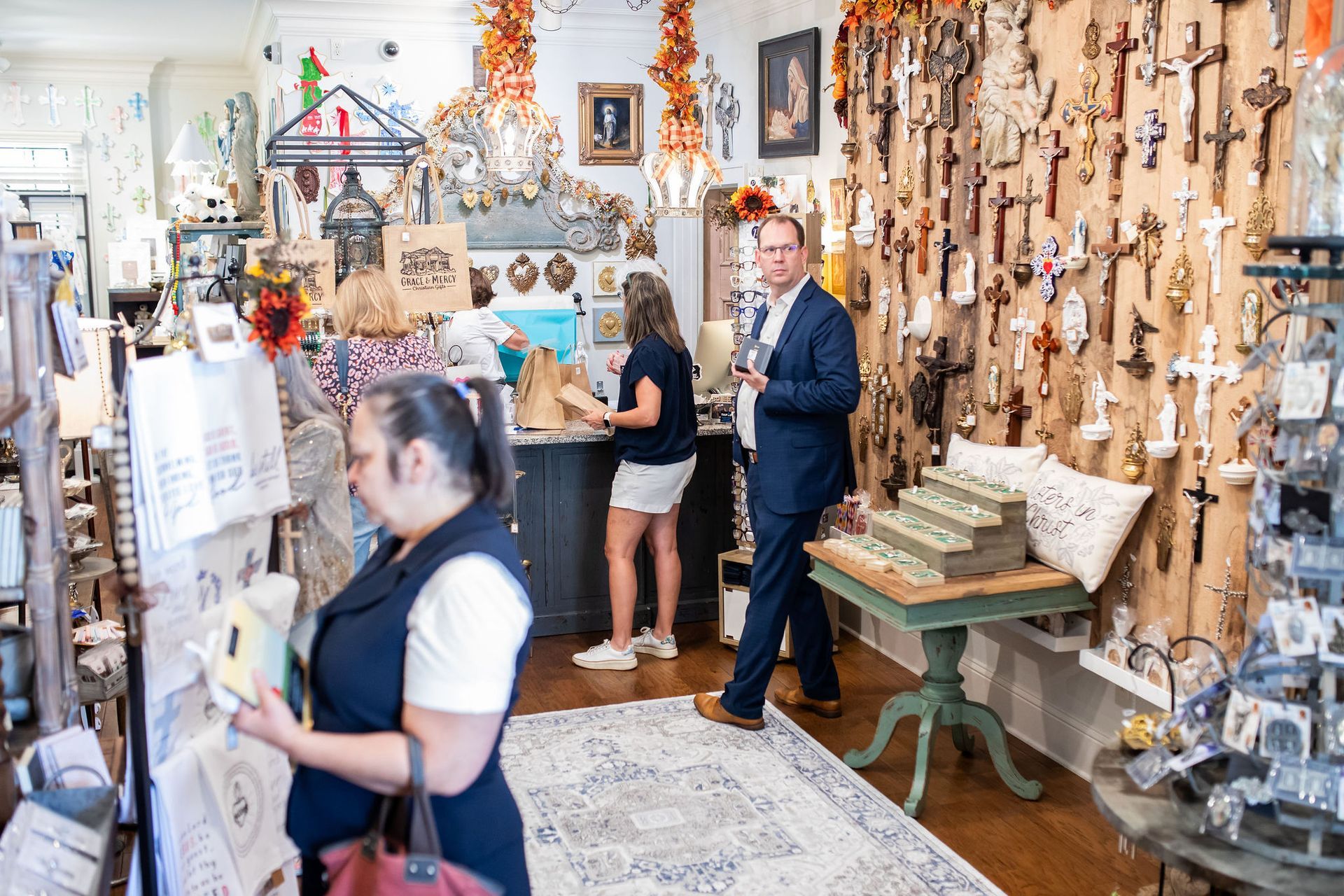 Inside a shop filled with crosses, people browse and shop.