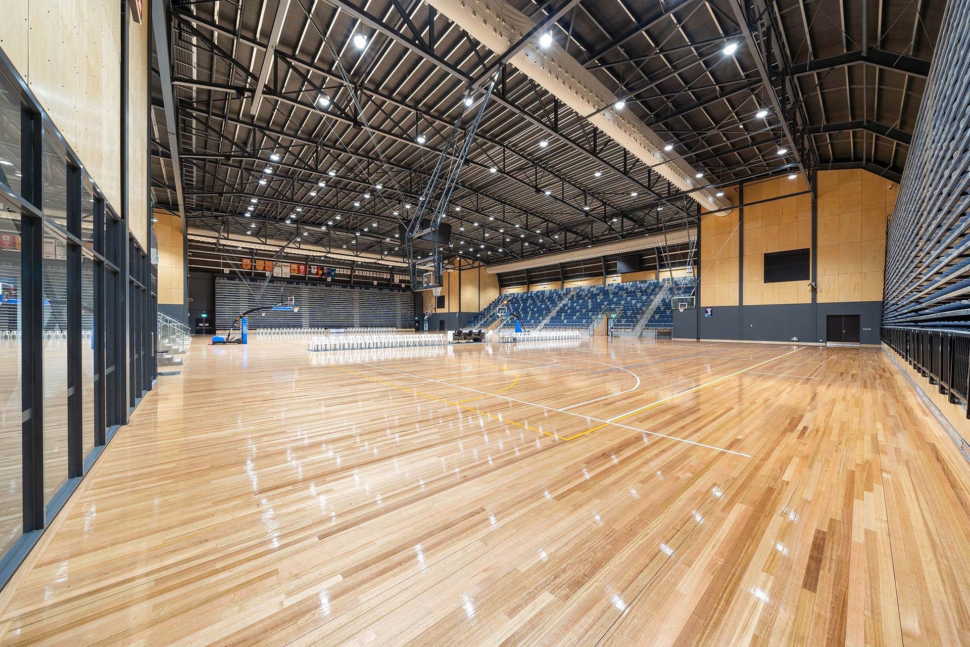A large indoor basketball court with a wooden floor and bleachers.