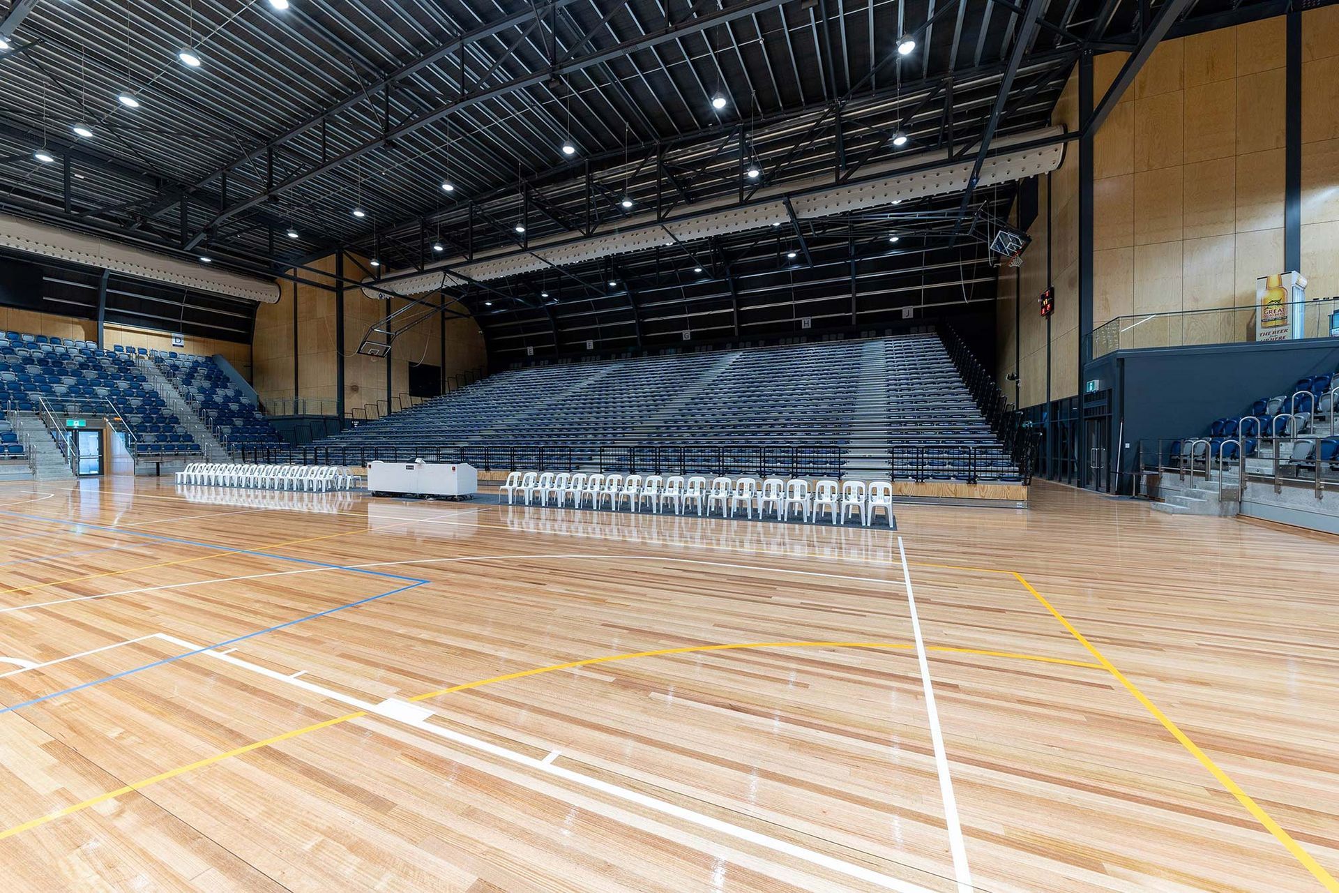 A large indoor stadium with wooden floors and bleachers.