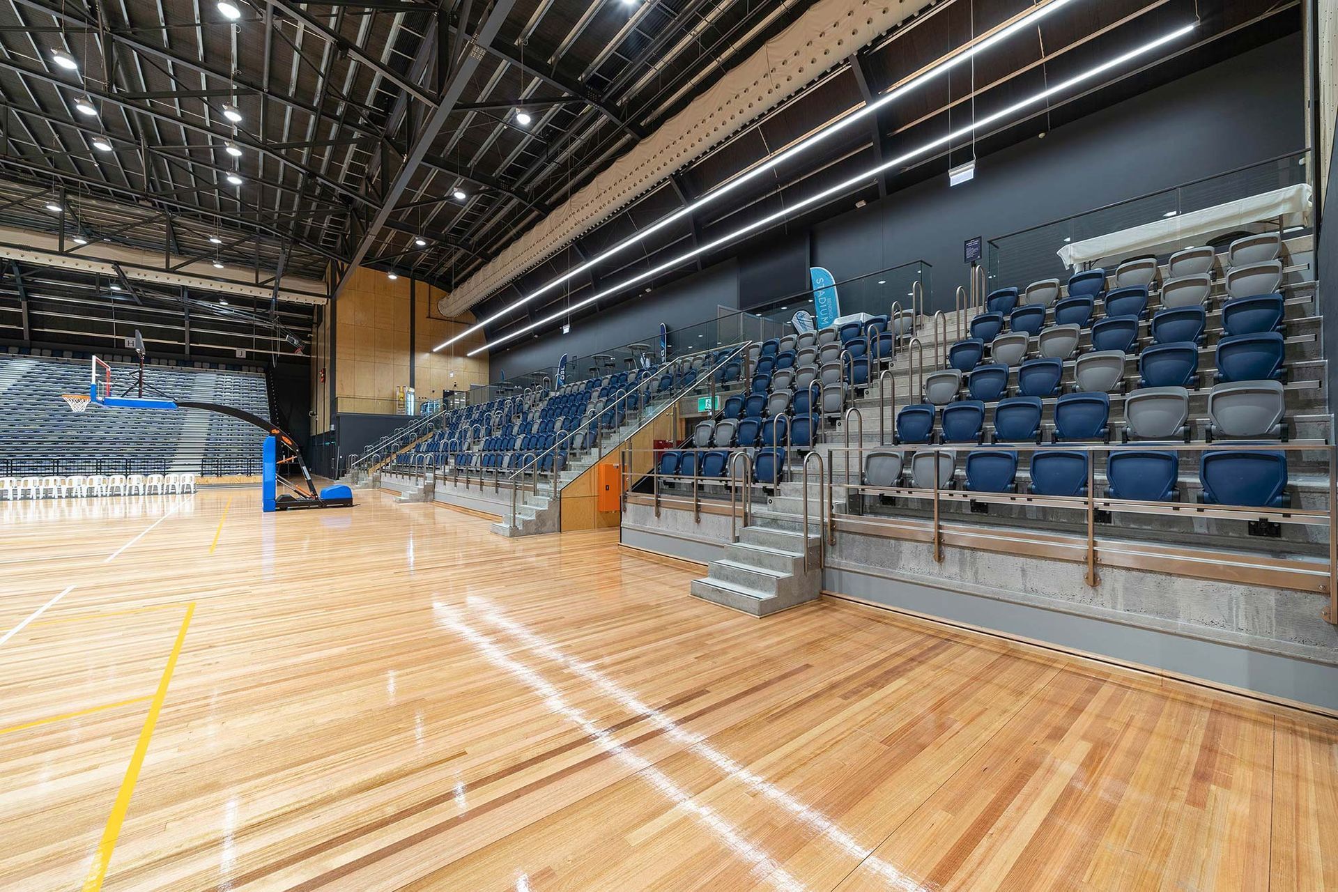A large empty stadium with wooden floors and bleachers.