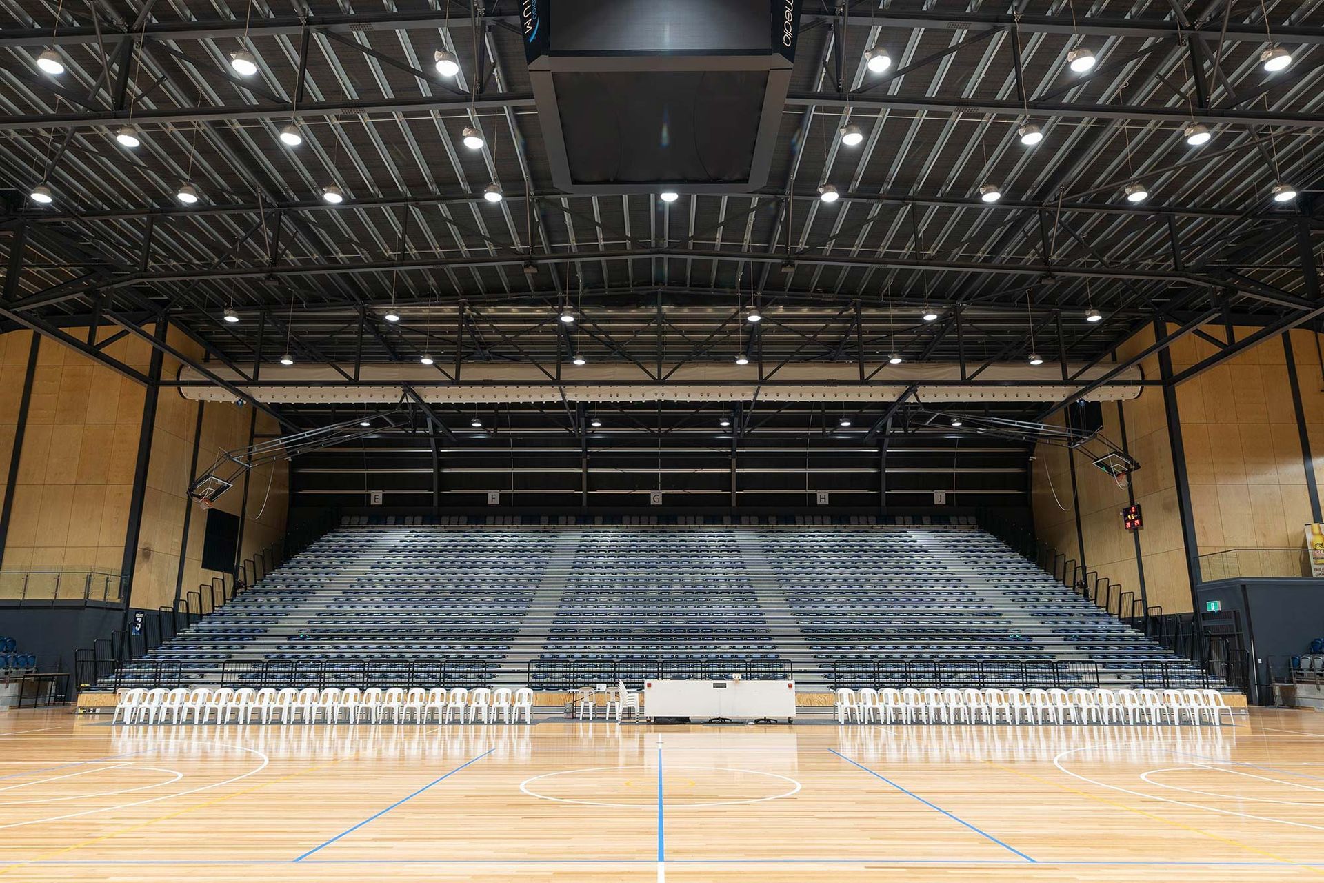 A large indoor stadium with bleachers and a basketball court.