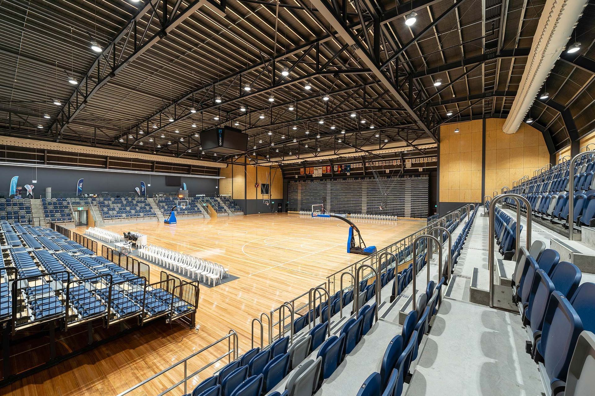 A large indoor stadium with rows of seats and a basketball court.