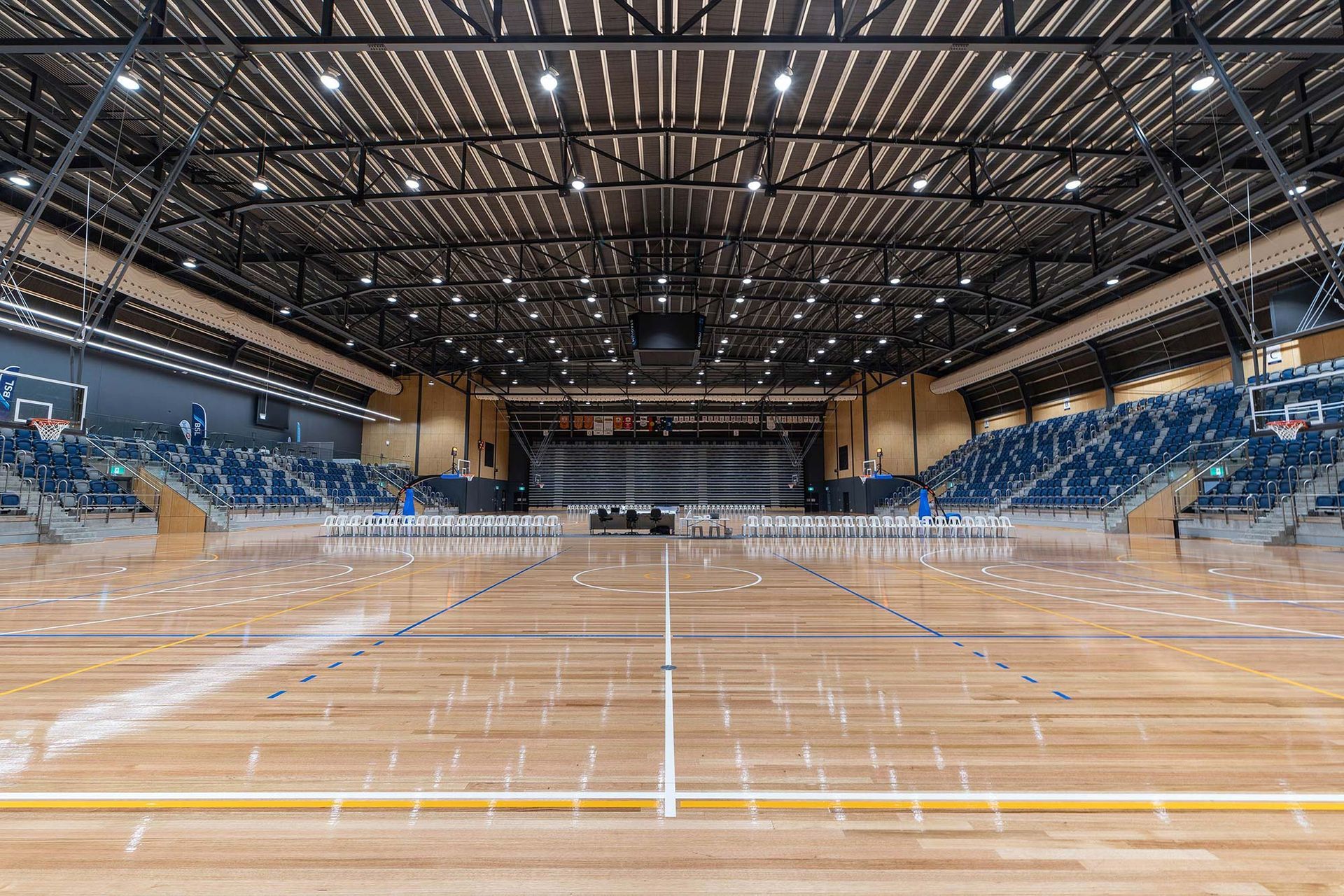 A large indoor basketball court with wooden floors and bleachers.