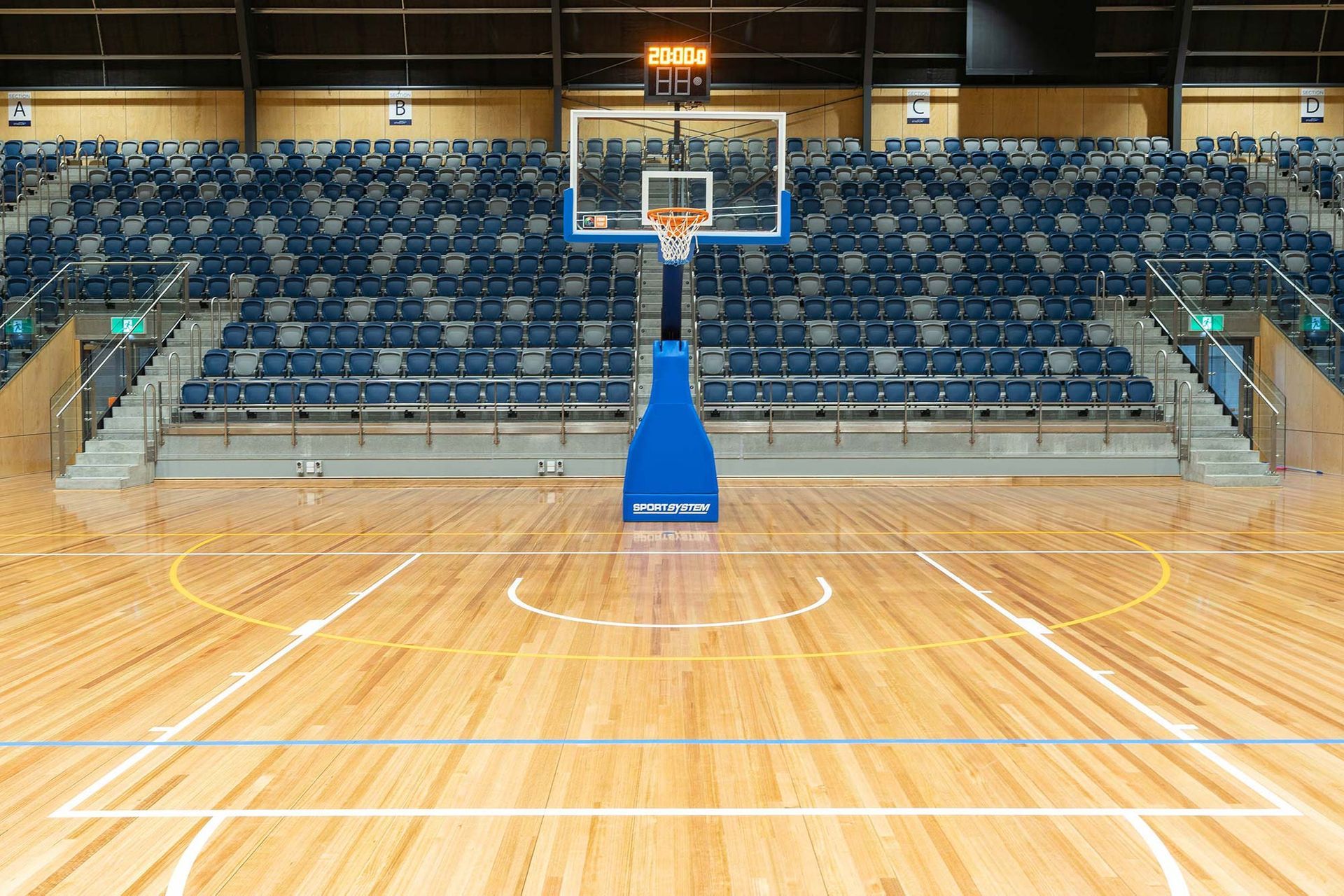 An empty basketball court with a basketball hoop and a scoreboard