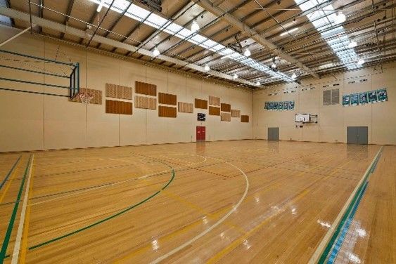 Indoor basketball court featuring polished wooden floors and a high ceiling. Indoor basketball court featuring polished wooden floors and a high ceiling.