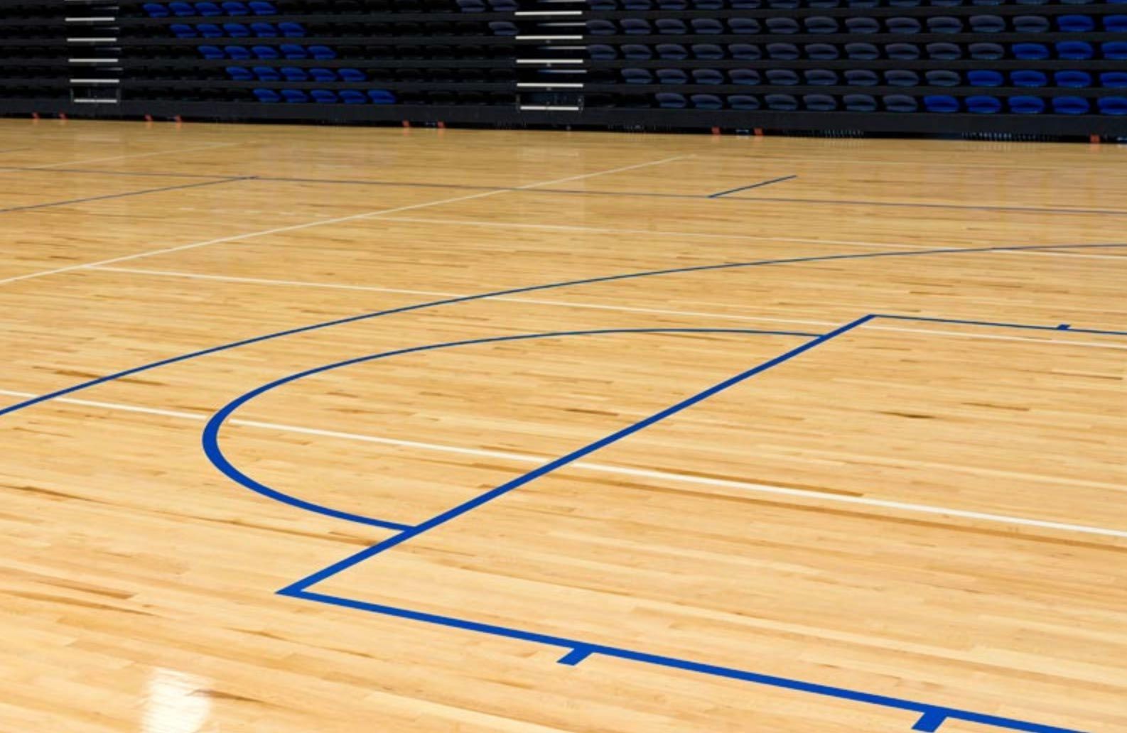 A wooden basketball court with blue lines on it