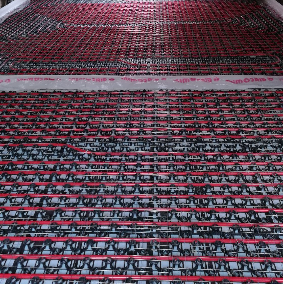 File di cavi o fili rossi e neri si estendevano sul pavimento di una fabbrica.
