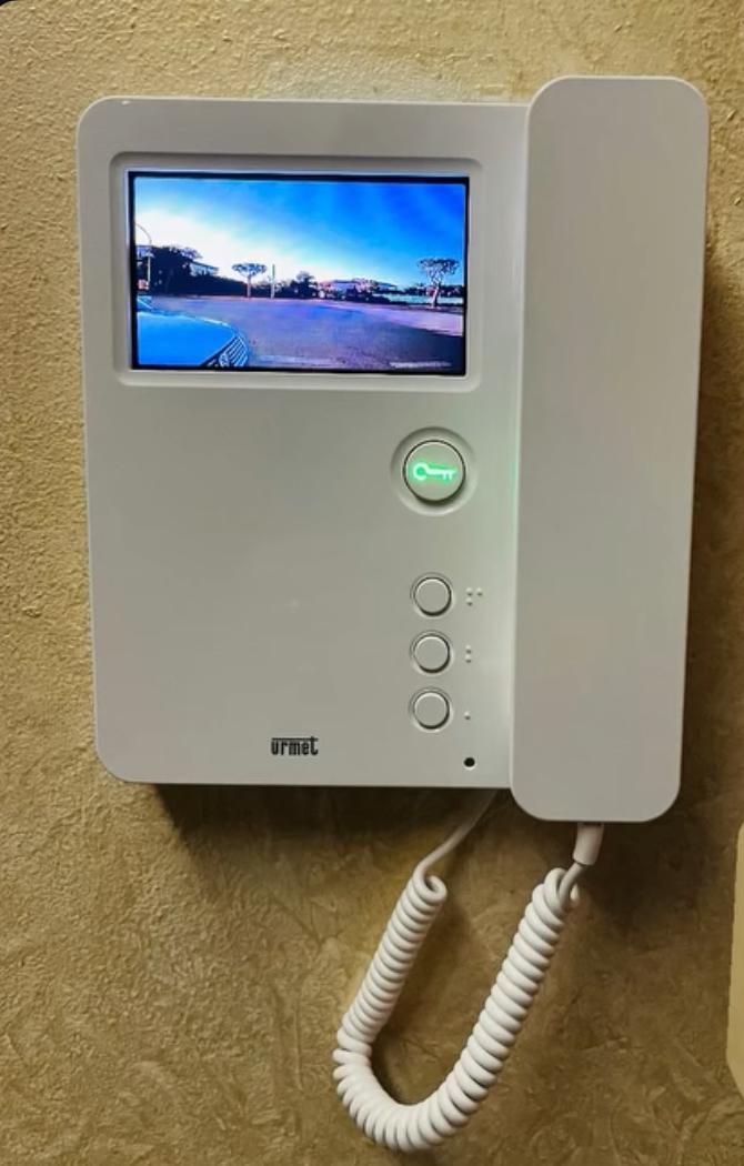 Persona che guarda il video in diretta di un fattorino tramite un campanello intelligente sul proprio telefono.