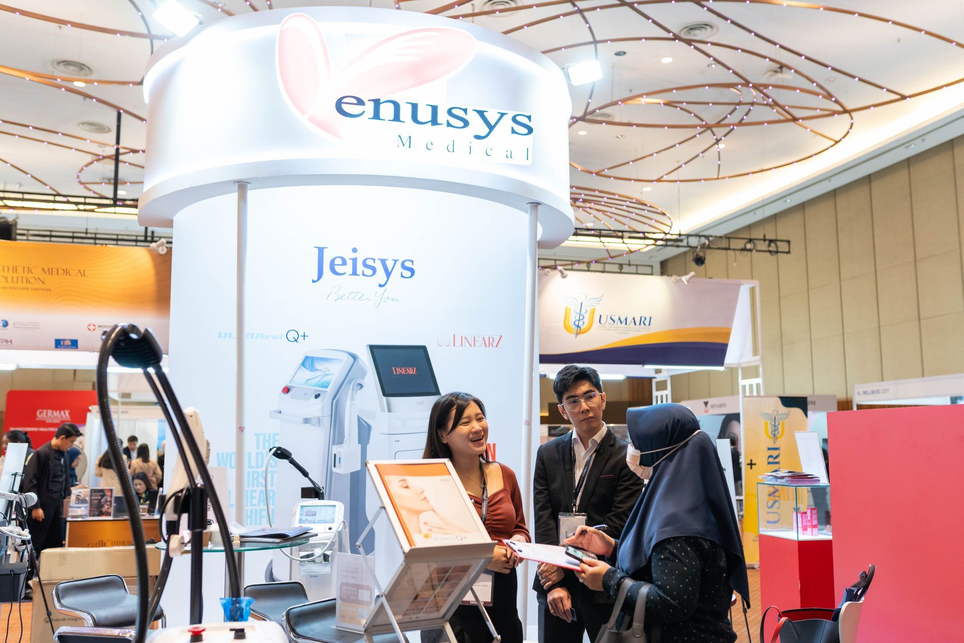 People at an exhibition booth for medical technology. A booth shows 