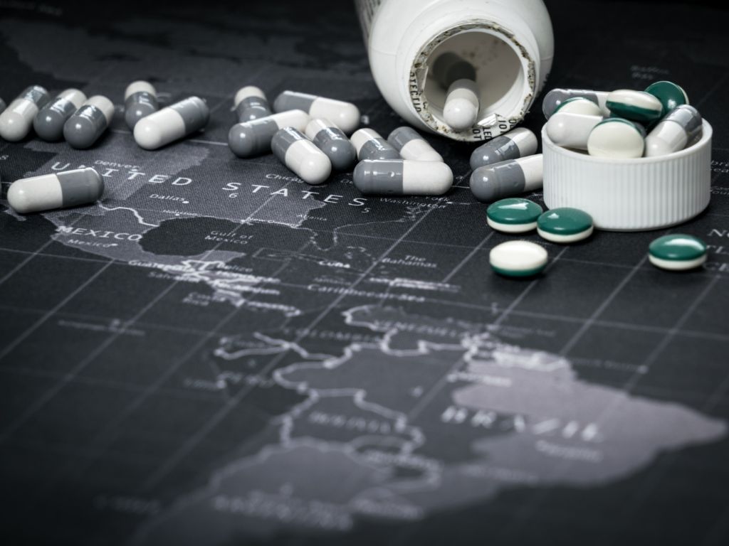 real time data logger A bottle of pills is spilling over a map of the world