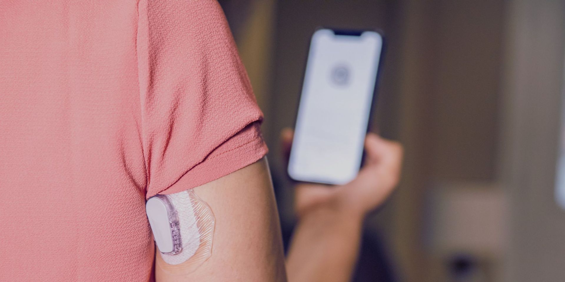 A woman with a patch on her arm is holding a cell phone.