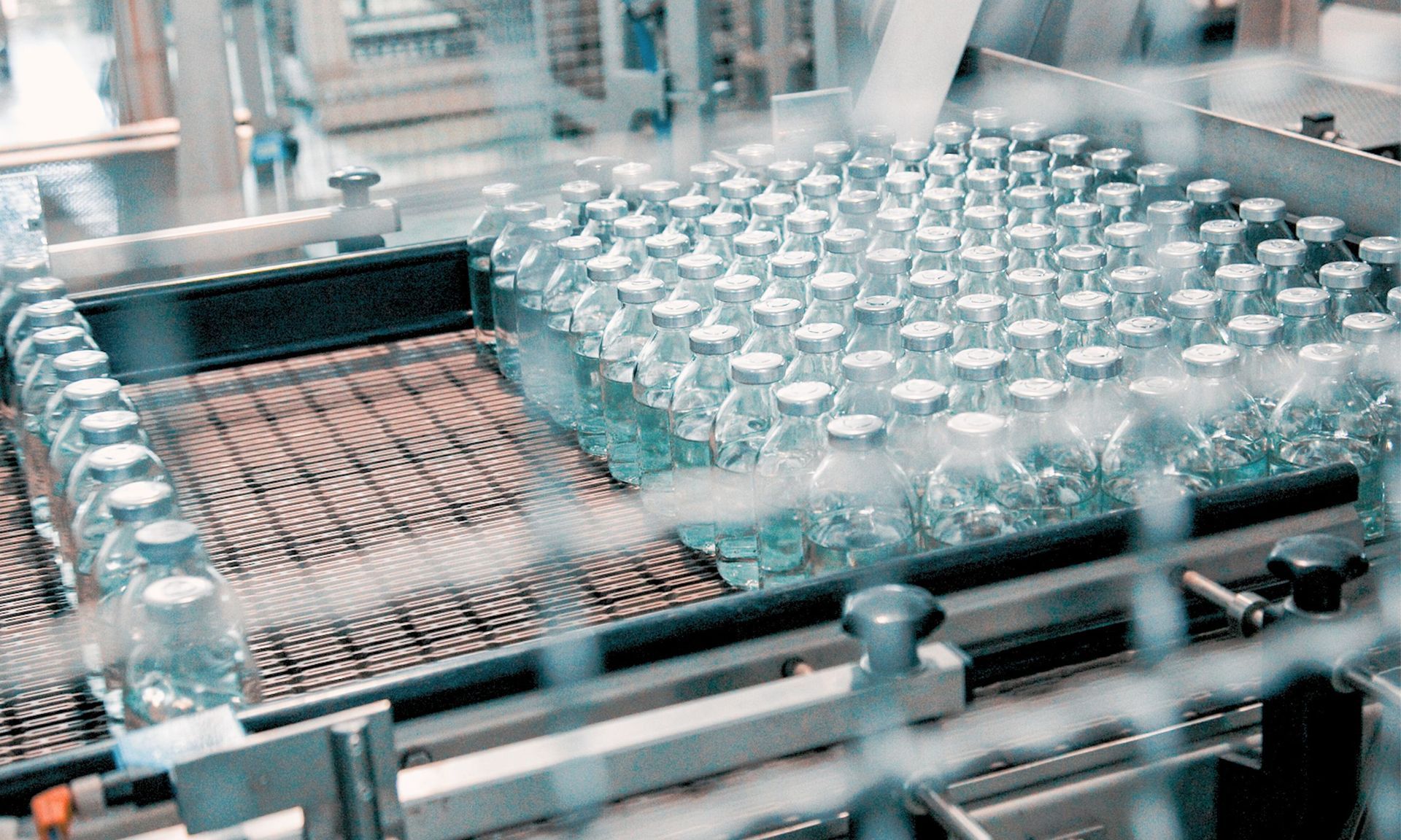 A conveyor belt filled with bottles of water in a factory.