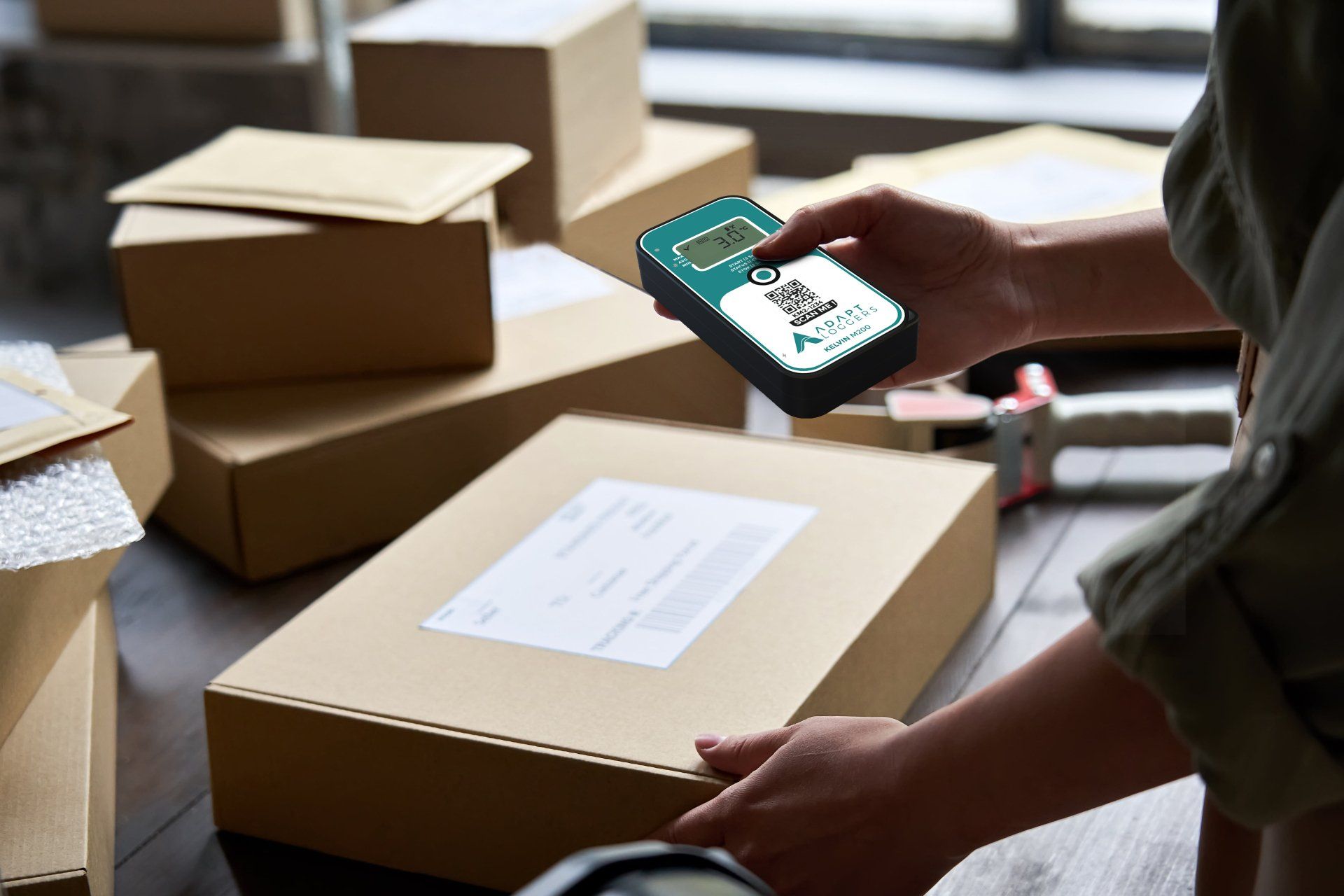A person is scanning a box with a barcode scanner.