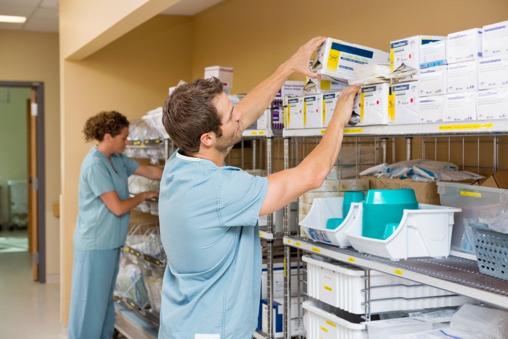 A man and a woman are working in a hospital warehouse.