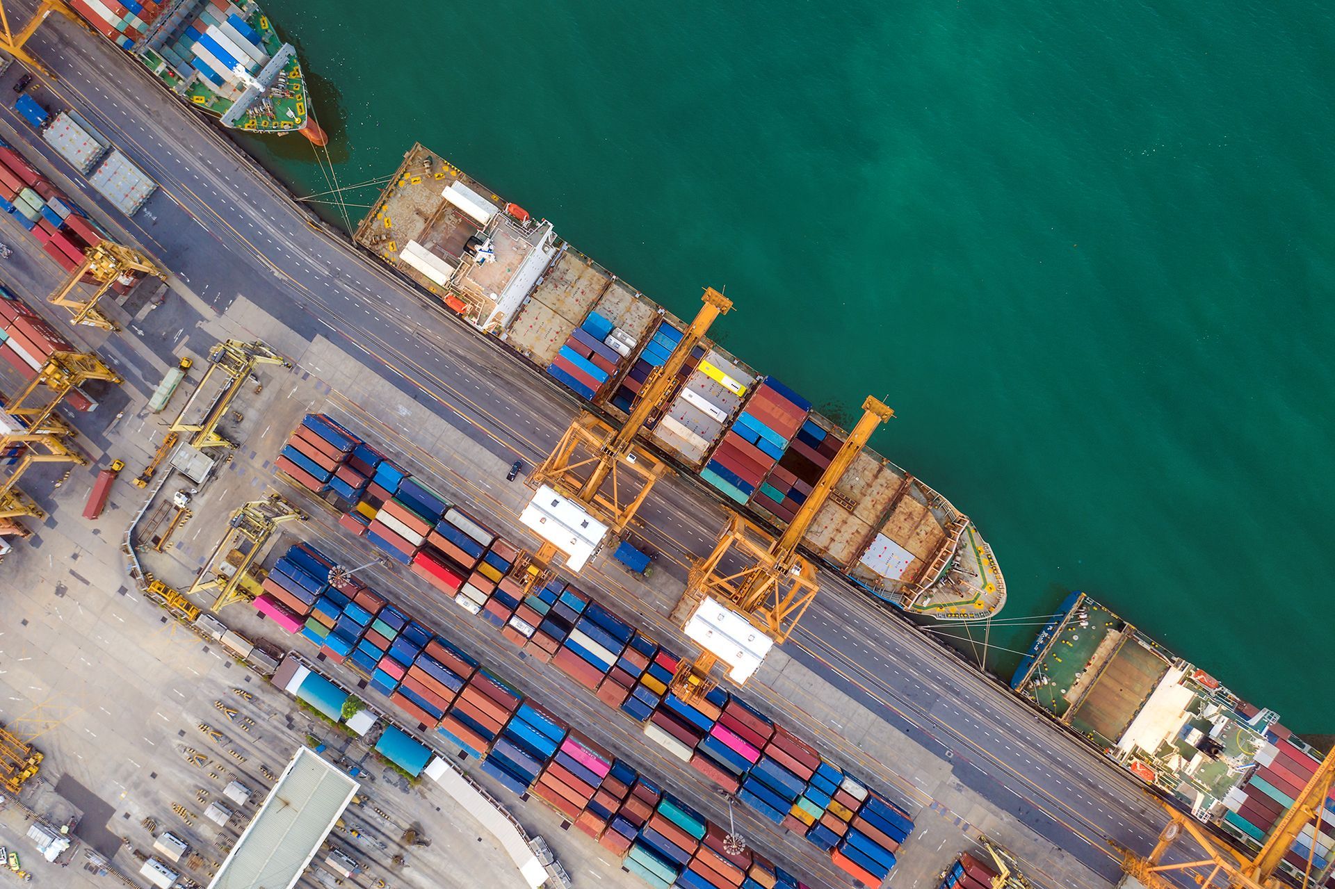 An aerial view of a container ship docked in a harbor.