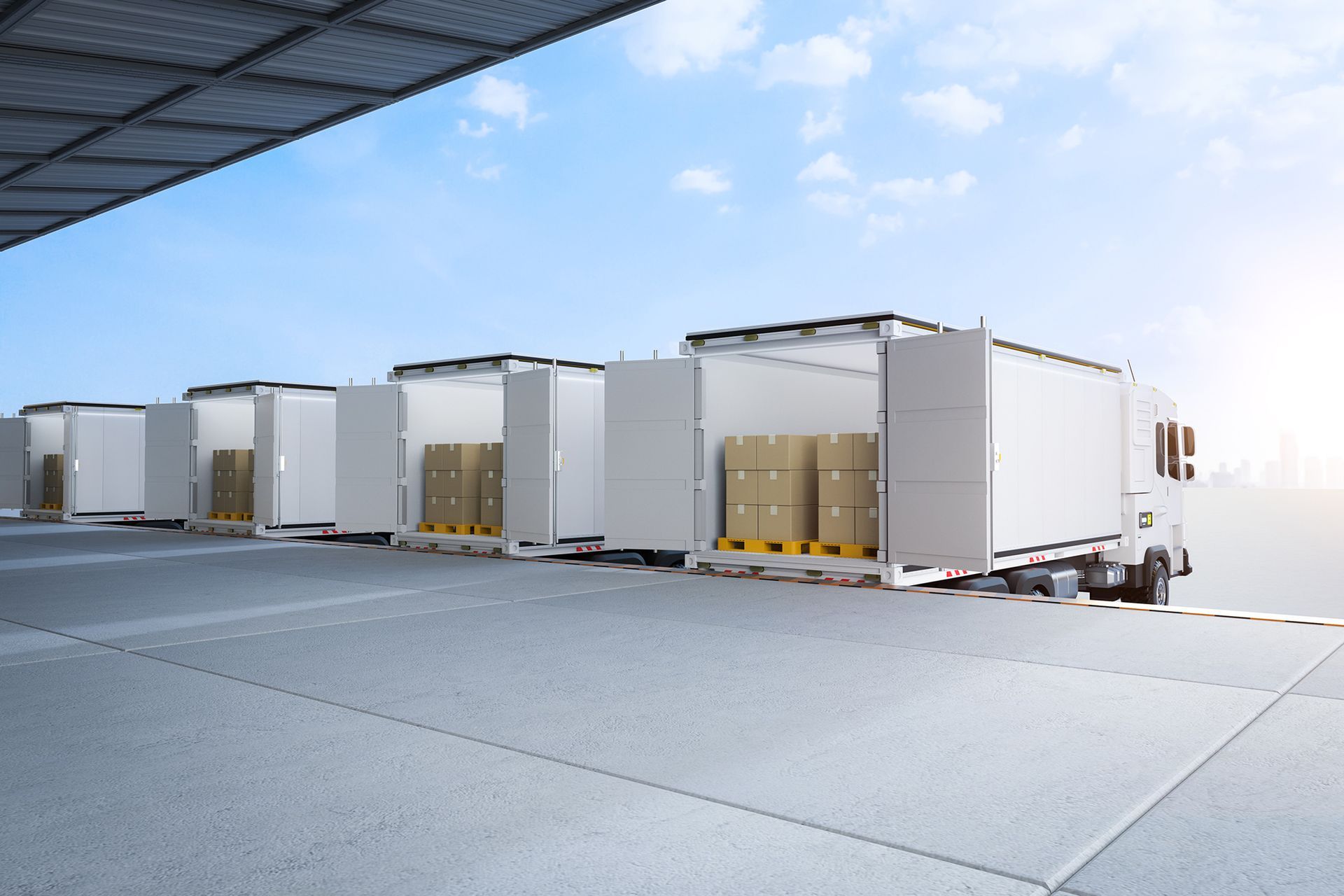 Trucks loaded with boxes A row of white semi trucks filled with boxes in a warehouse.