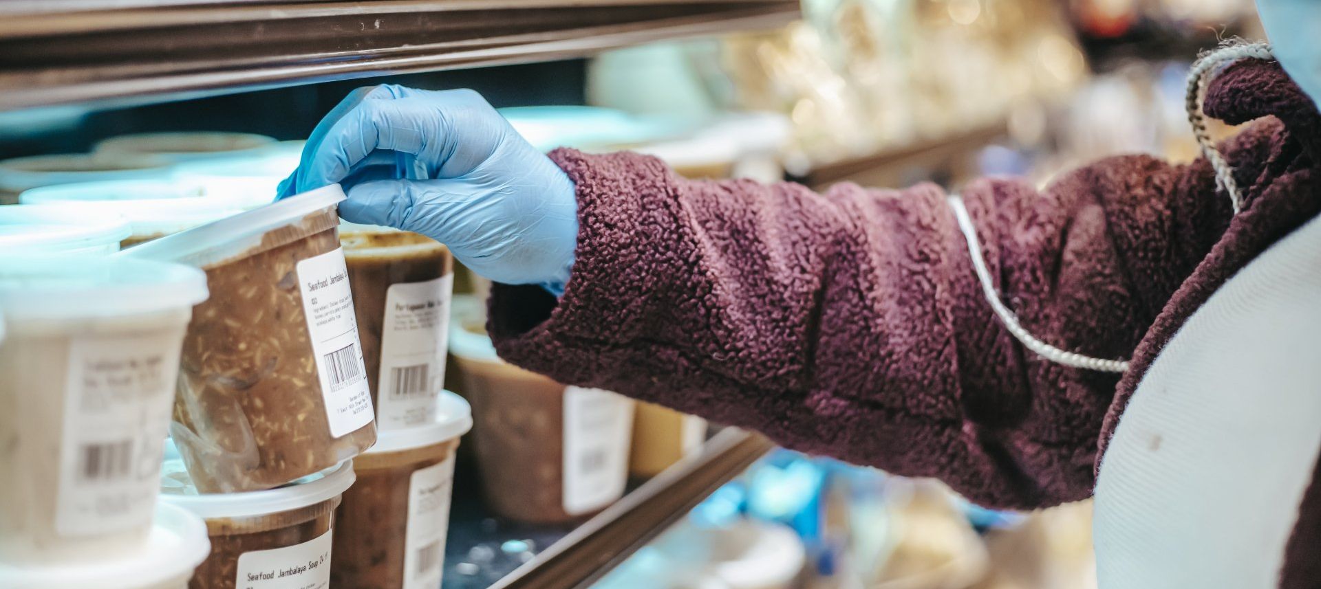 real time data logger A person wearing blue gloves is reaching into a refrigerator.