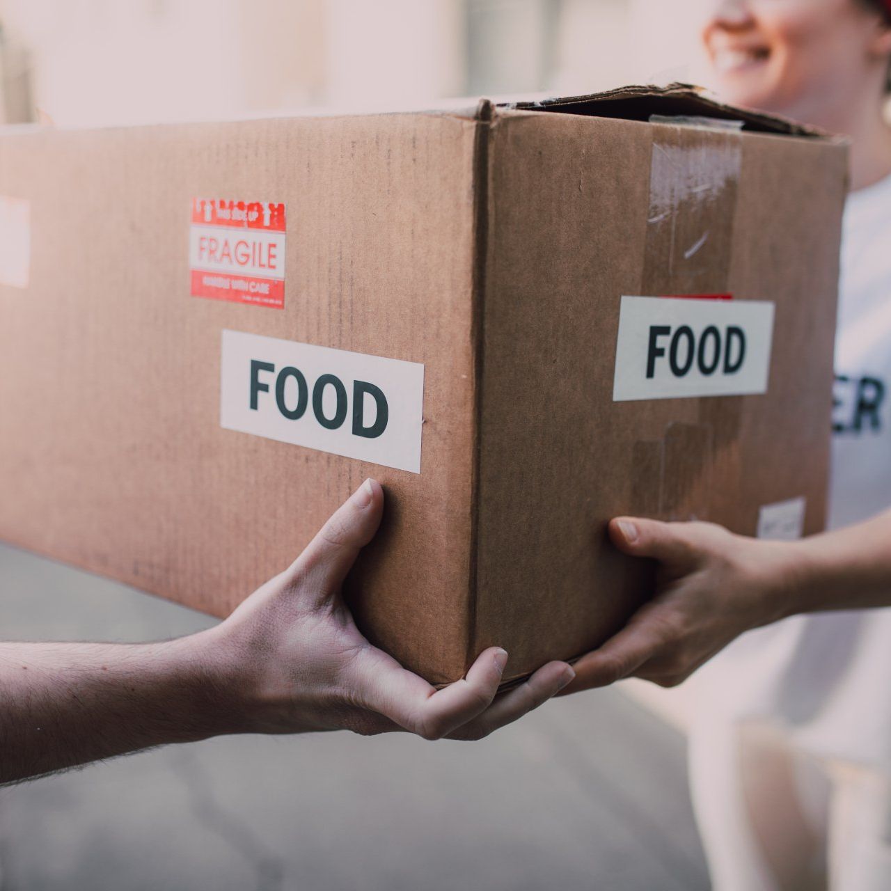 A person is holding a box that says food on it