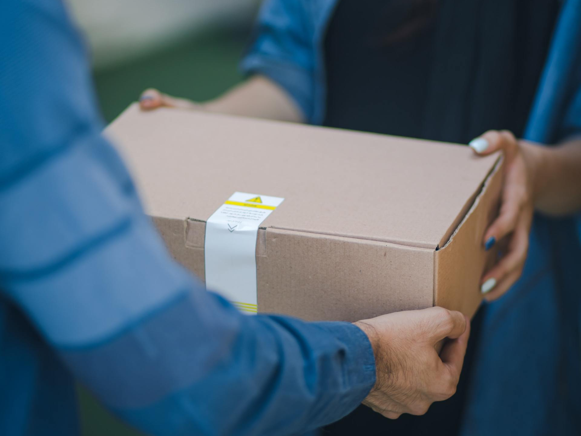 A man is handing a box to a woman.