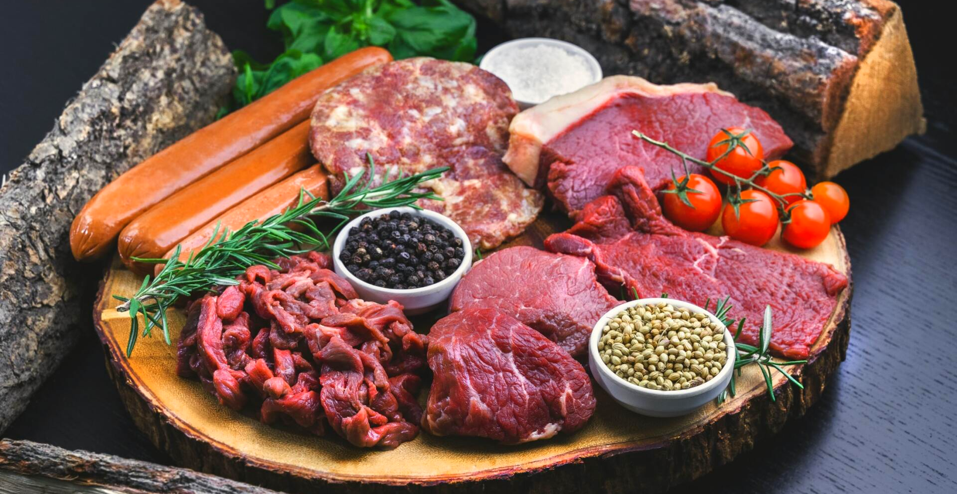 A wooden cutting board topped with a variety of meats and vegetables.
